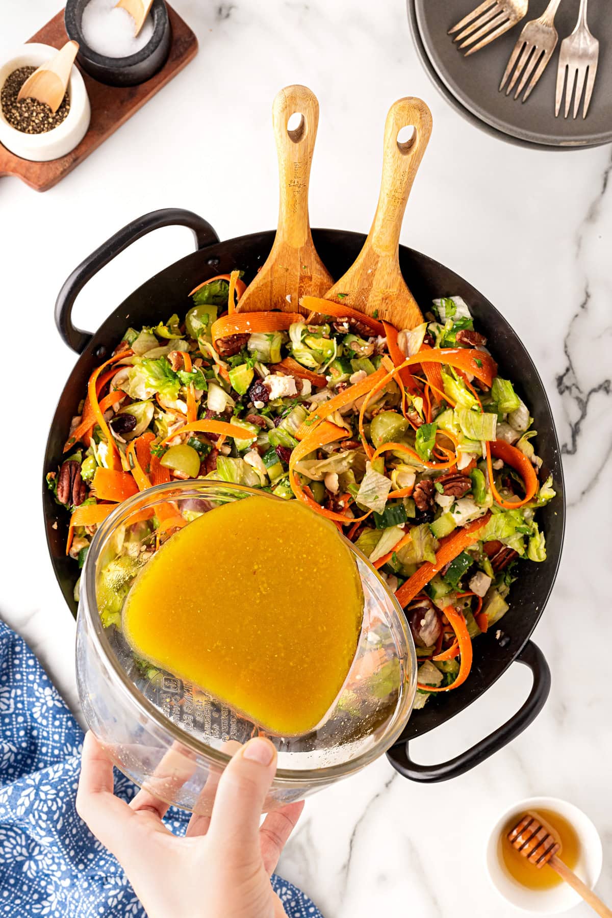 Pouring dressing on salad.