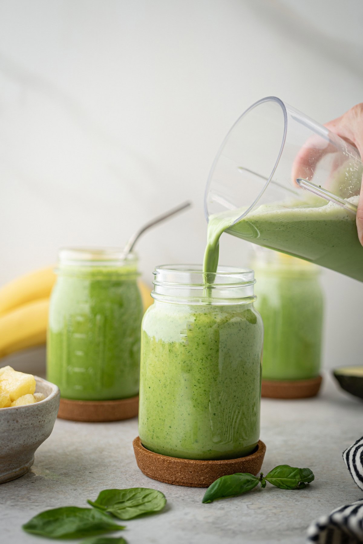 Pouring a Green Smoothie into a glass.
