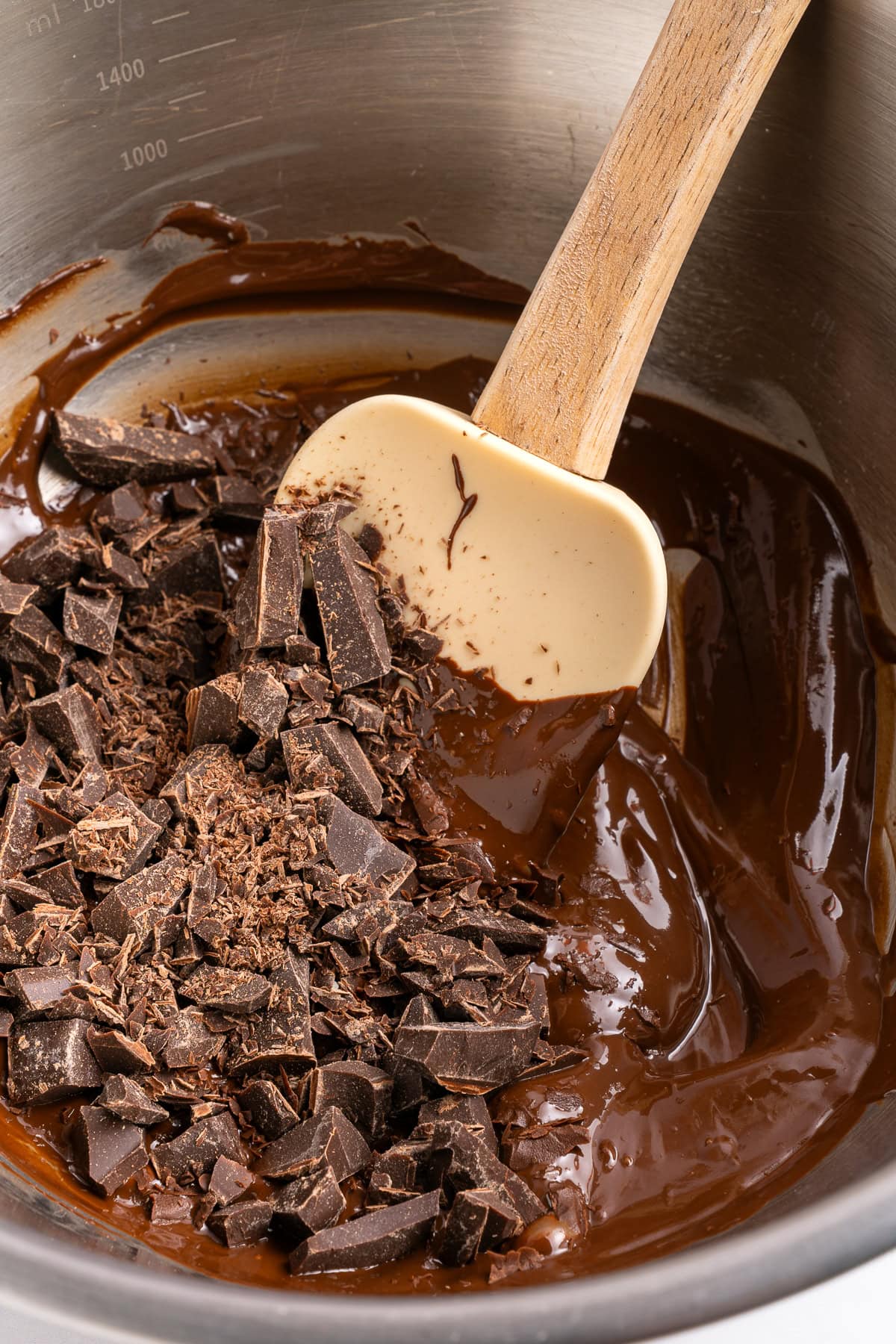 Mixing melted chocolate with chopped chocolate.