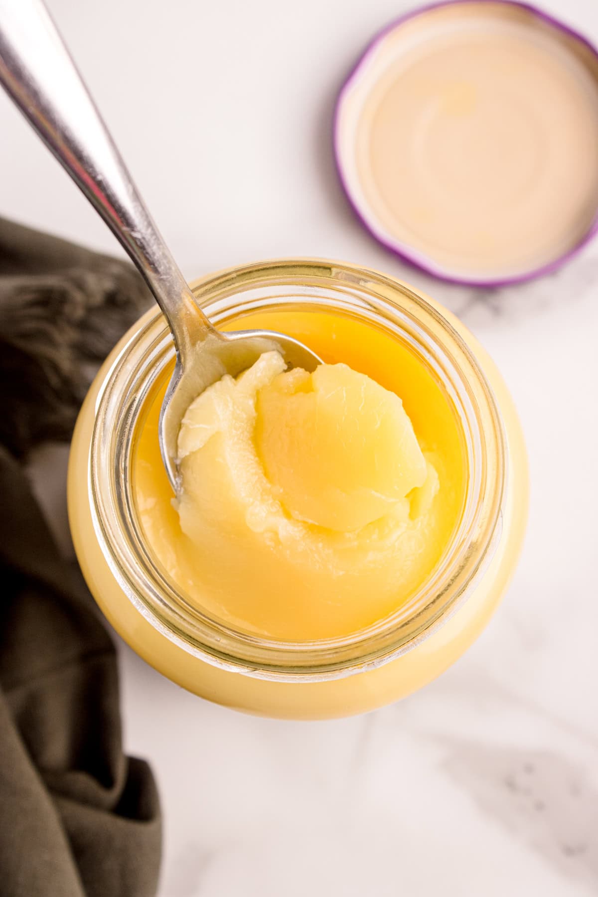 Spooning out ghee from the jar. 