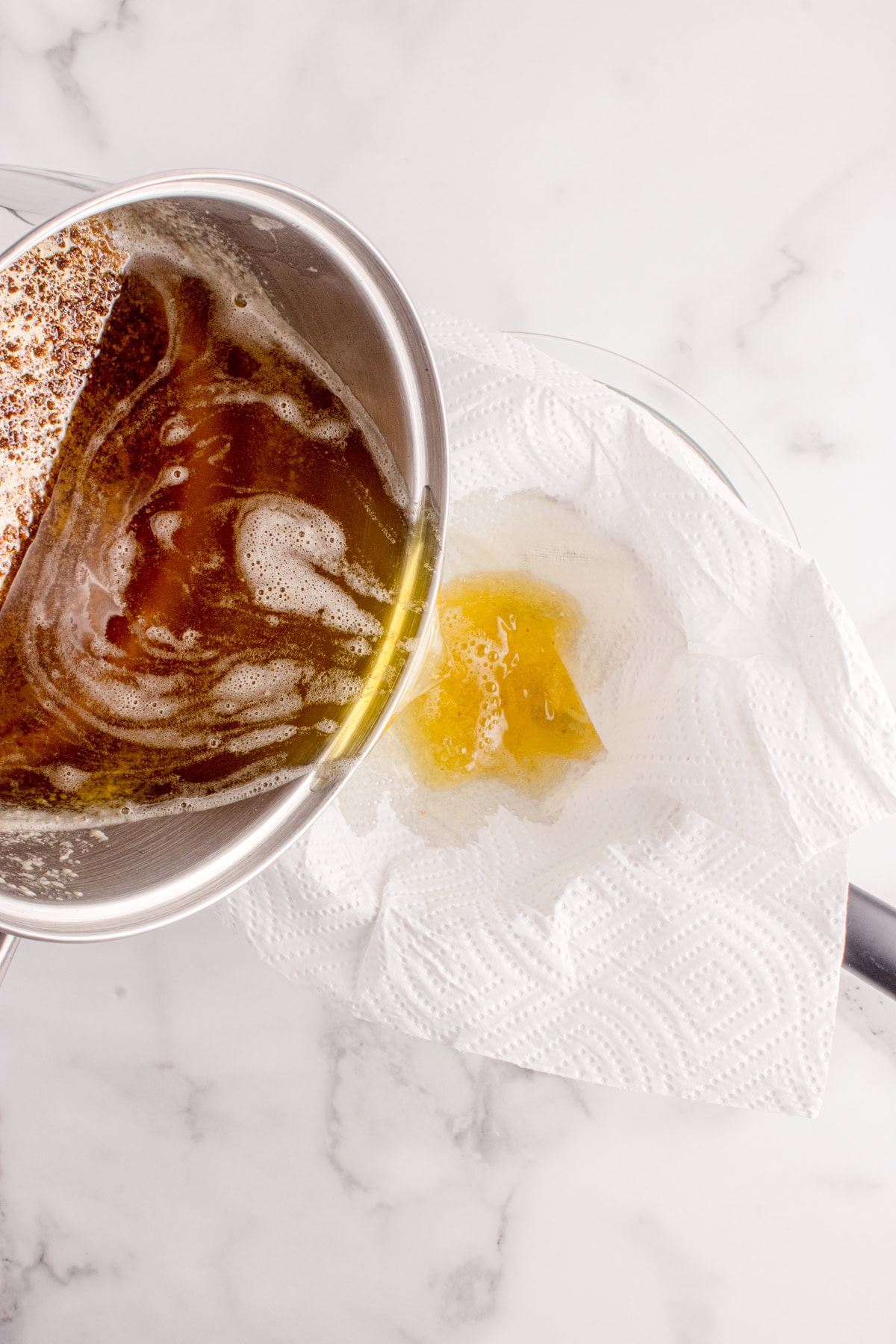 Pouring butter through a paper towel lined sieve. 