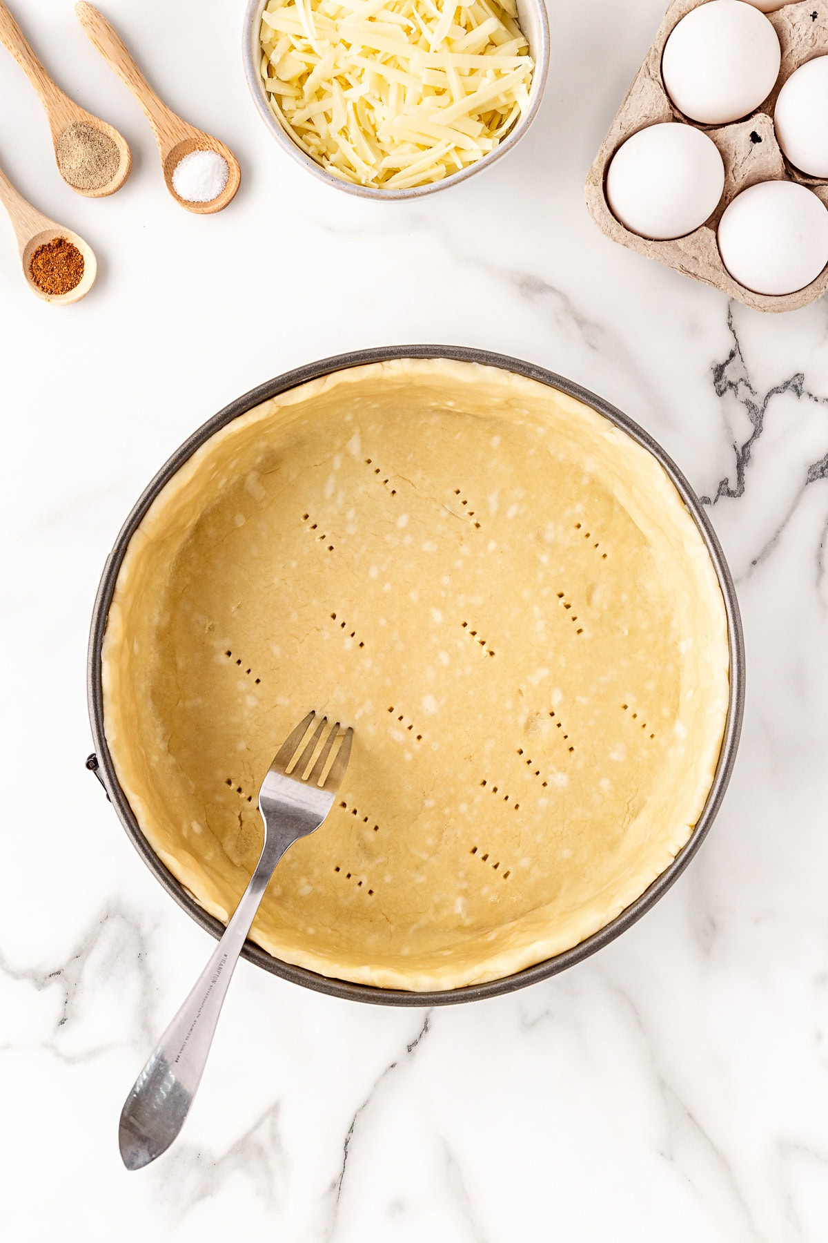 Pricking a fork into the pastry in the pan. 