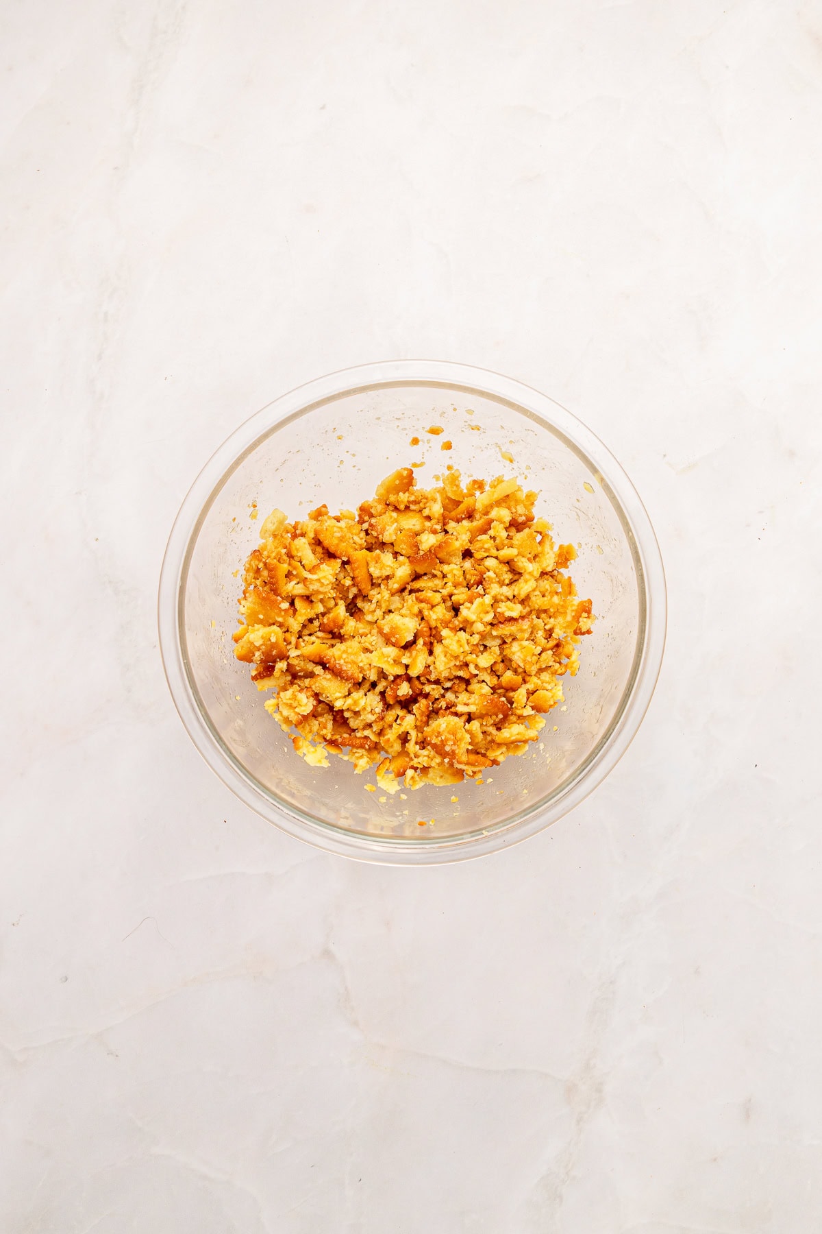 Mixing crackers and melted butter.