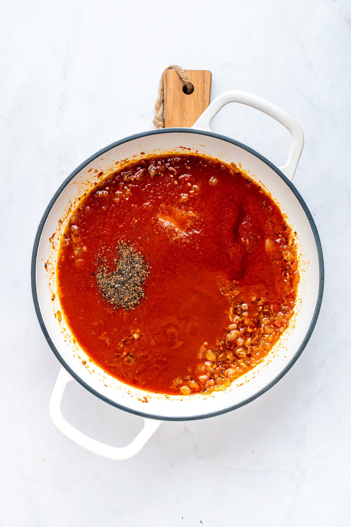 Incorporating tomato passata to the skillet.