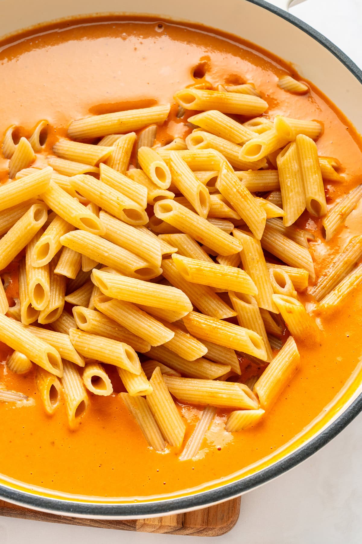 Tossing the pasta with rose sauce.