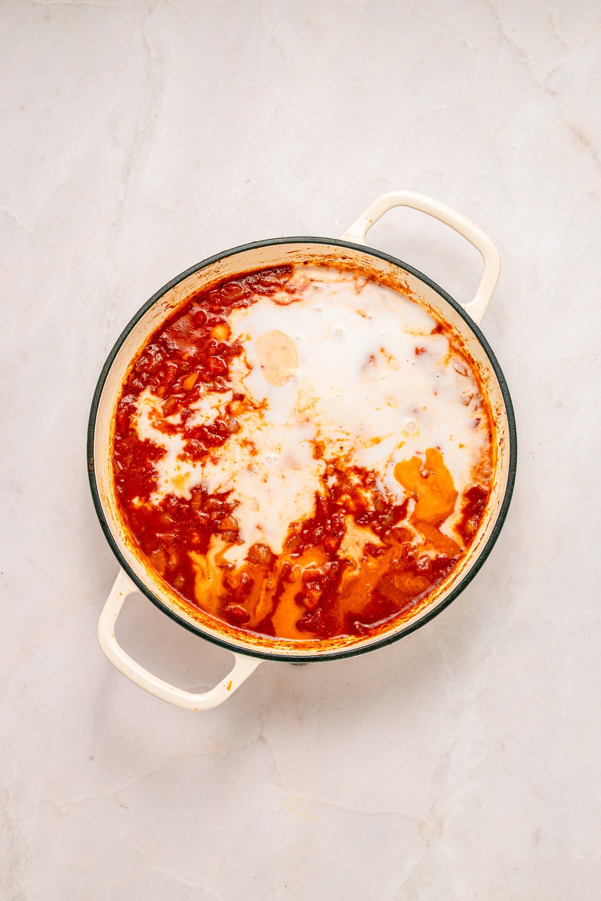 Adding coconut milk to the sauce.