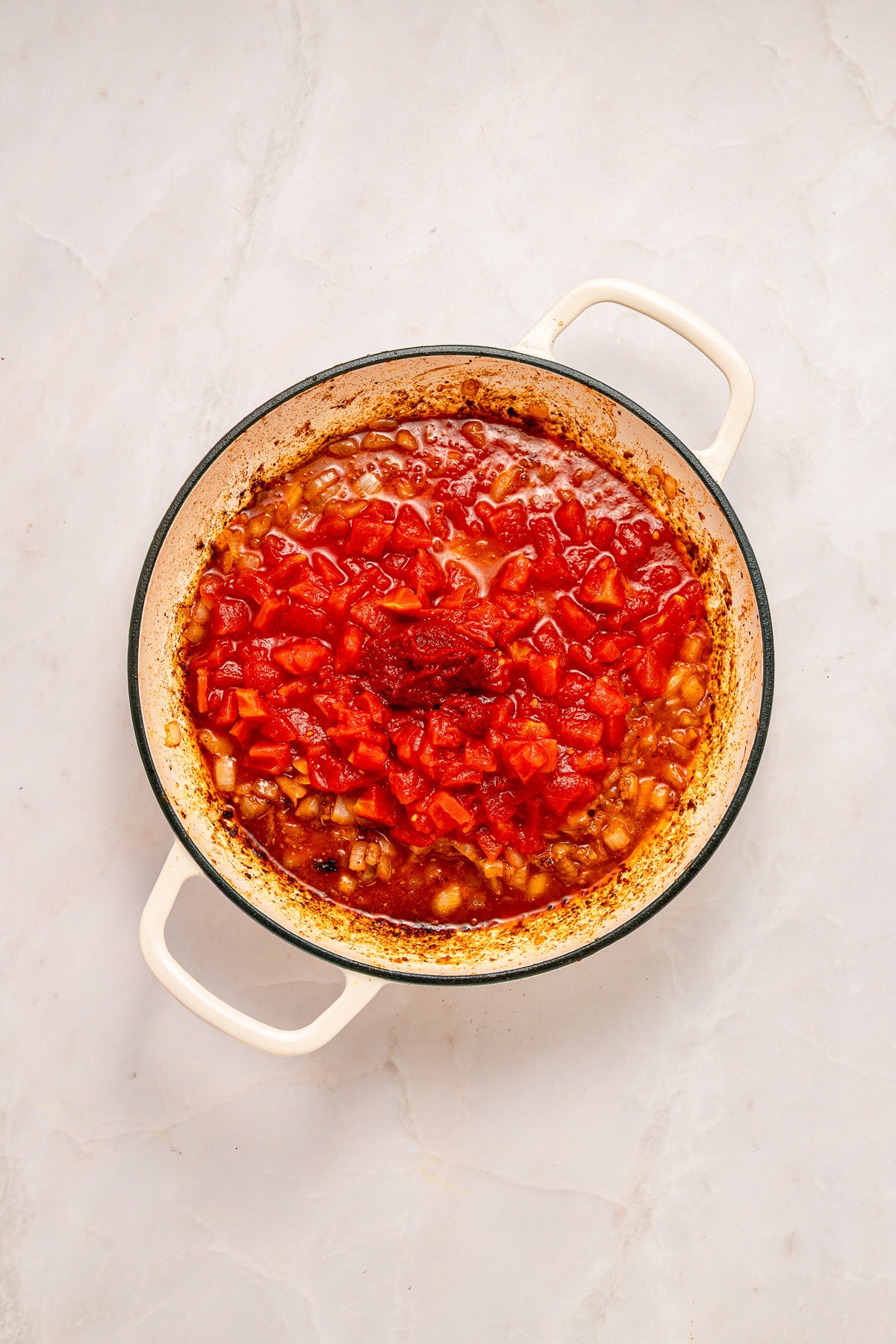 Incorporating crushed tomatoes and tomato paste.