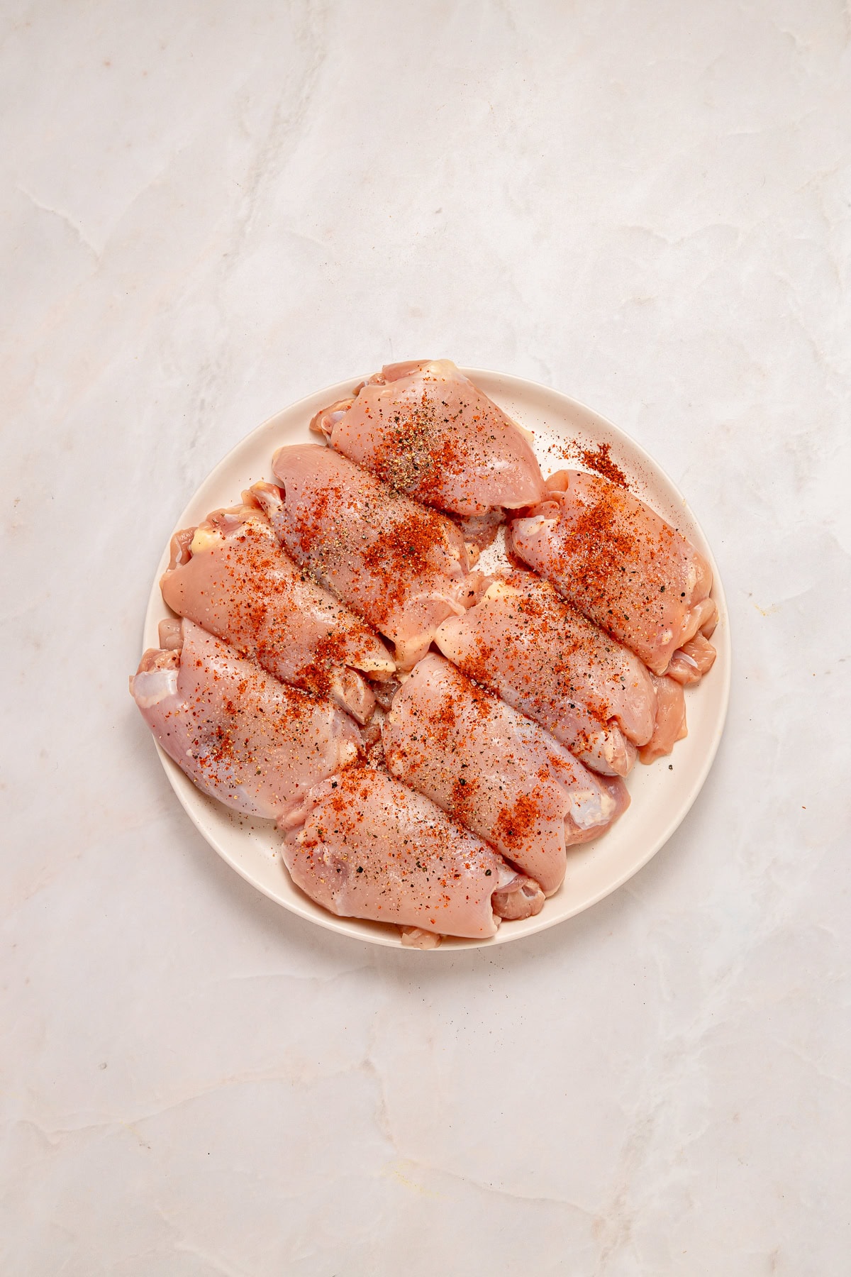 Seasoning chicken thighs.