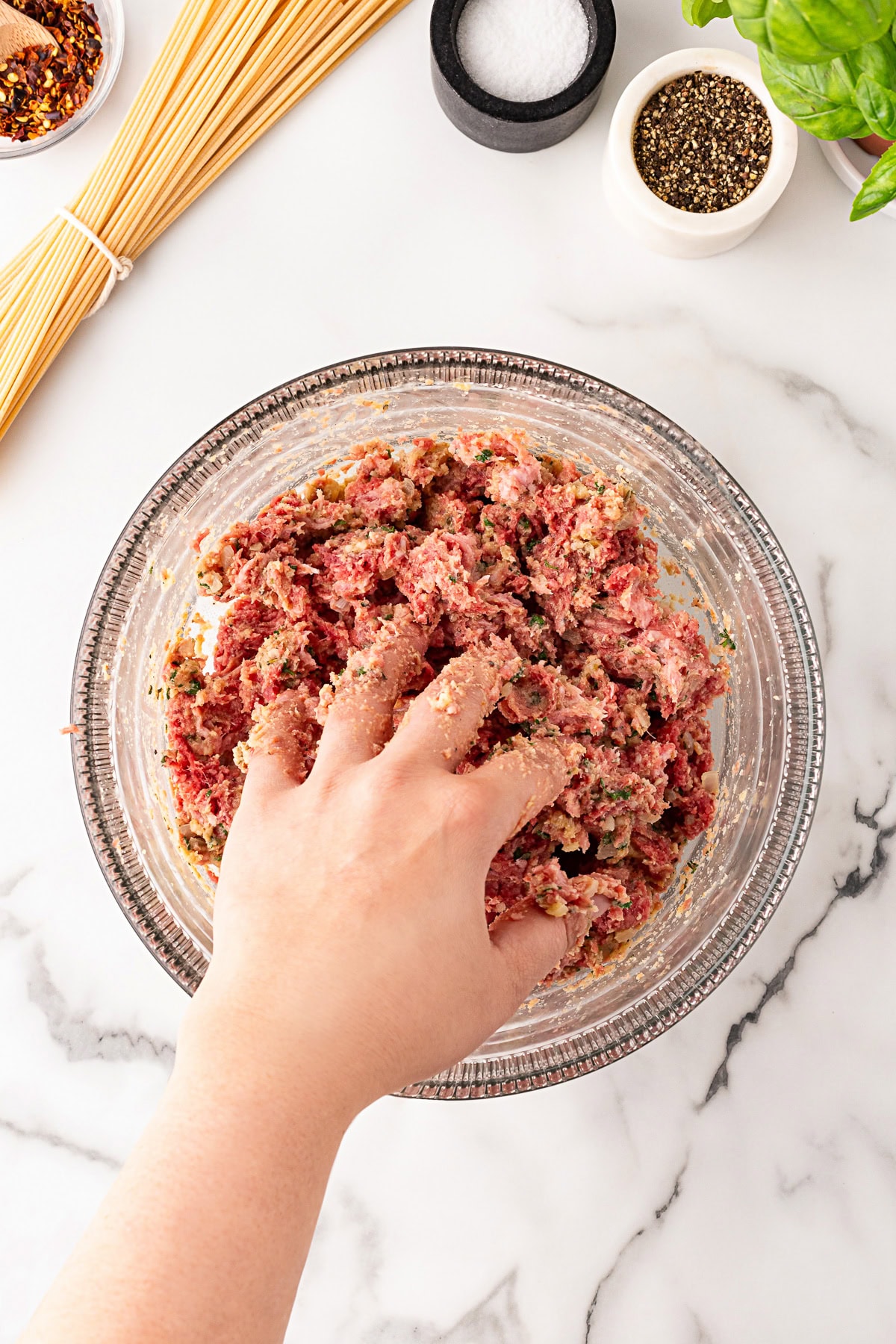 Using your hand as a pitchfork for mixing meat. 