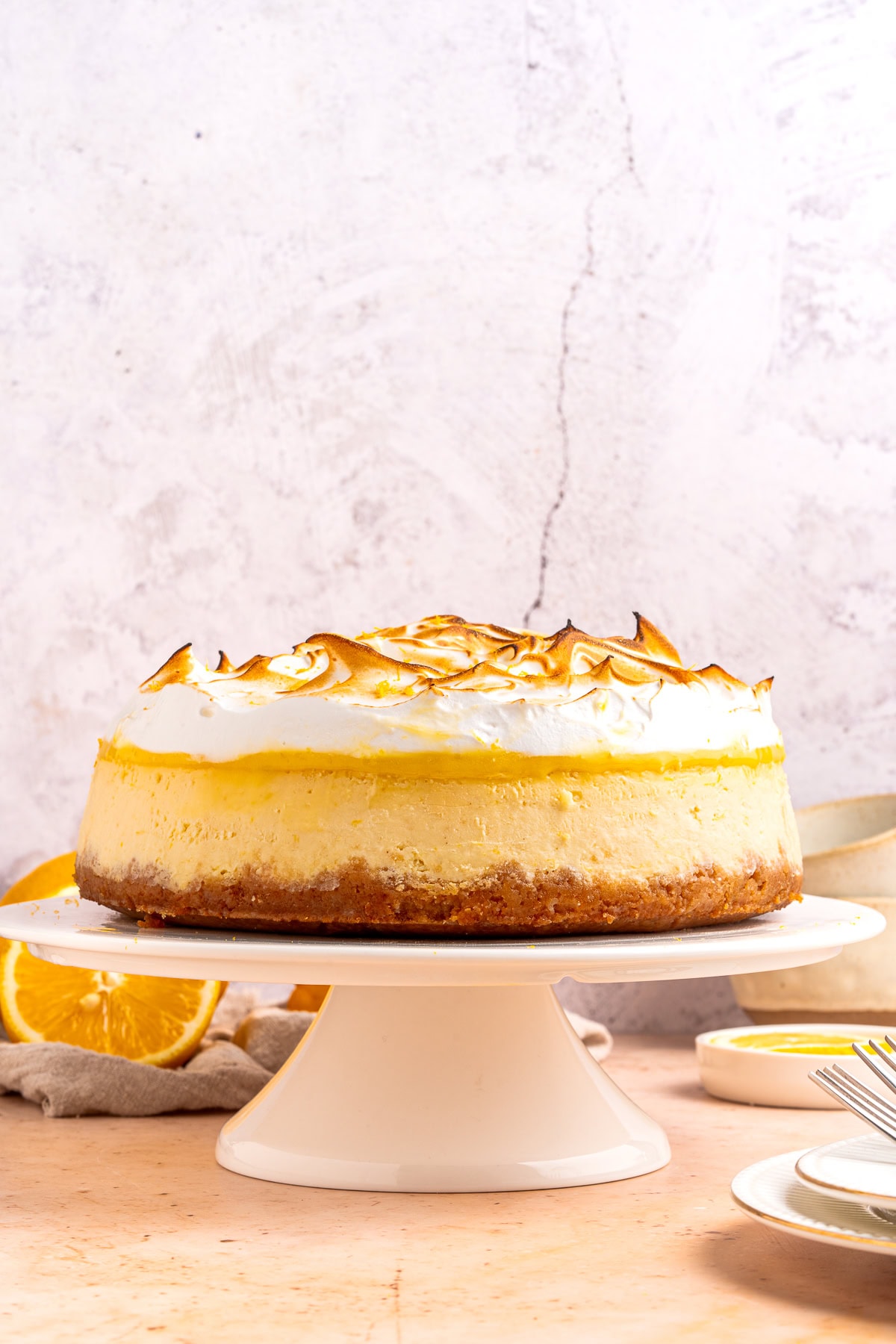 Lemon meringue cheesecake on a cake stand.