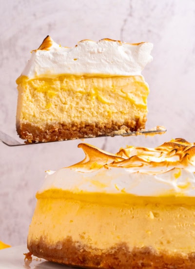 Holding up a slice of Lemon Meringue Cheesecake.