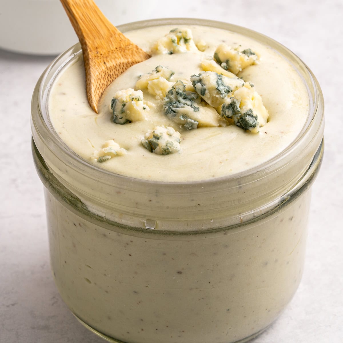Blue cheese dressing in a jar with spoon.