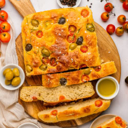 Overhead shot of focaccia sliced on a board.
