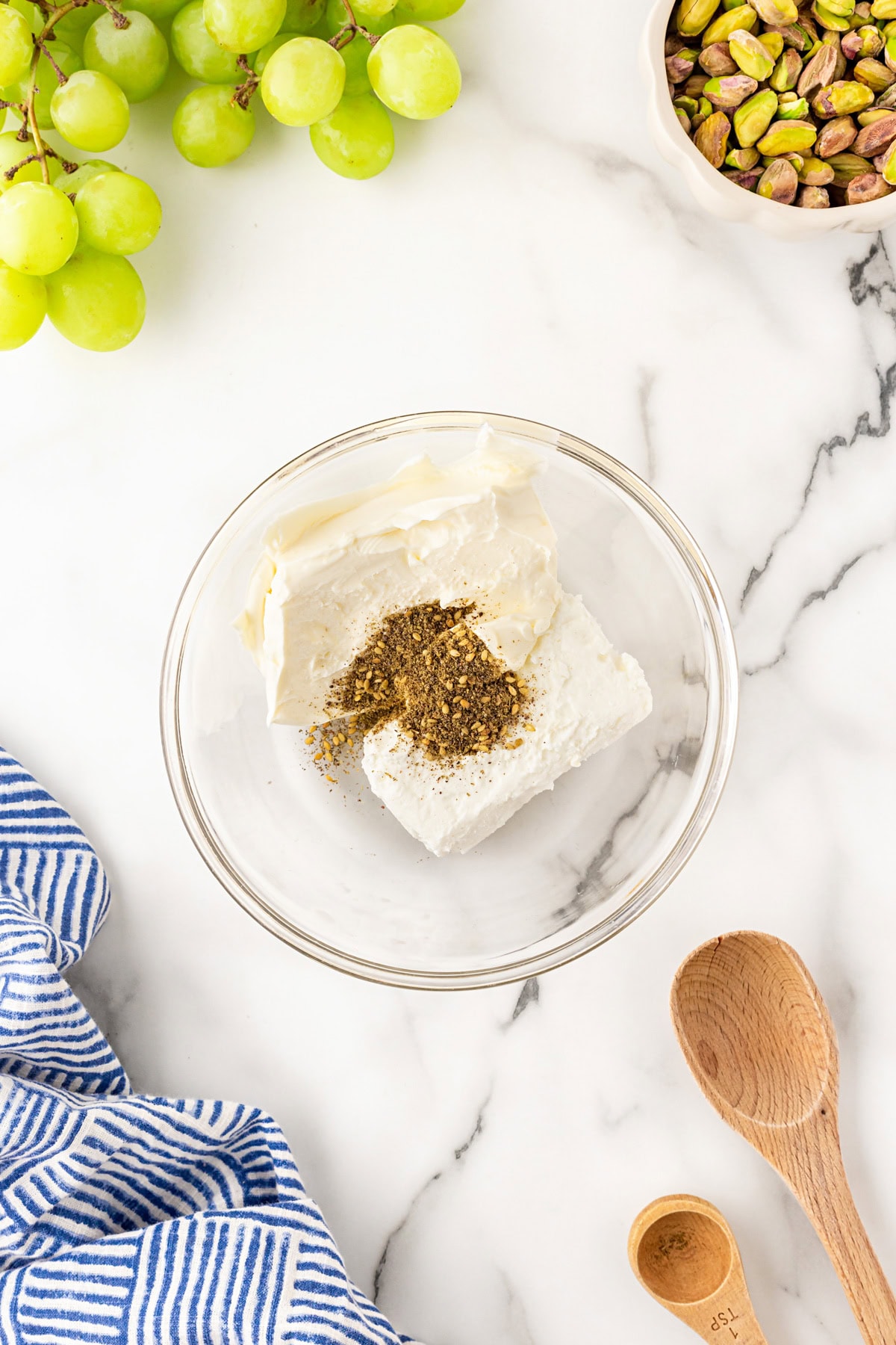 Adding za'atar to goat cheese and cream cheese. 