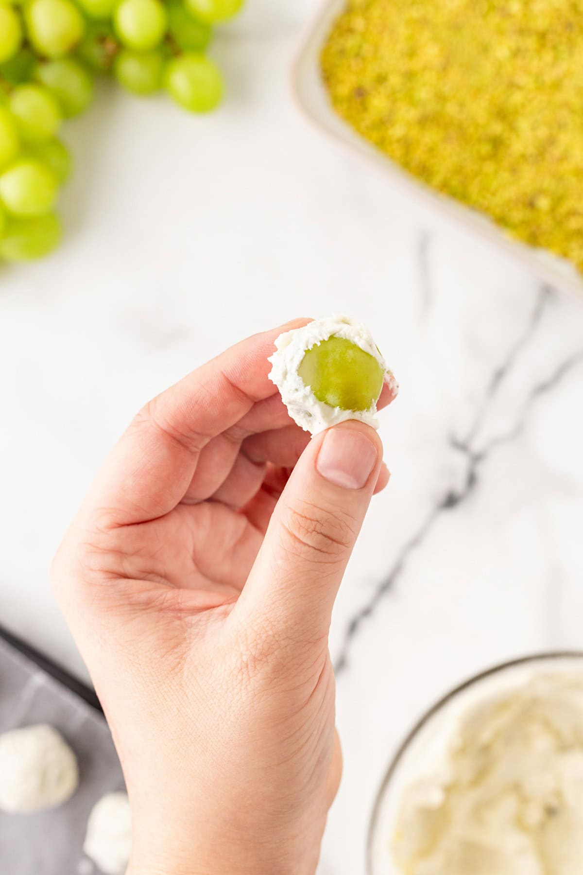 Wrapping goat cheese around a grape. 