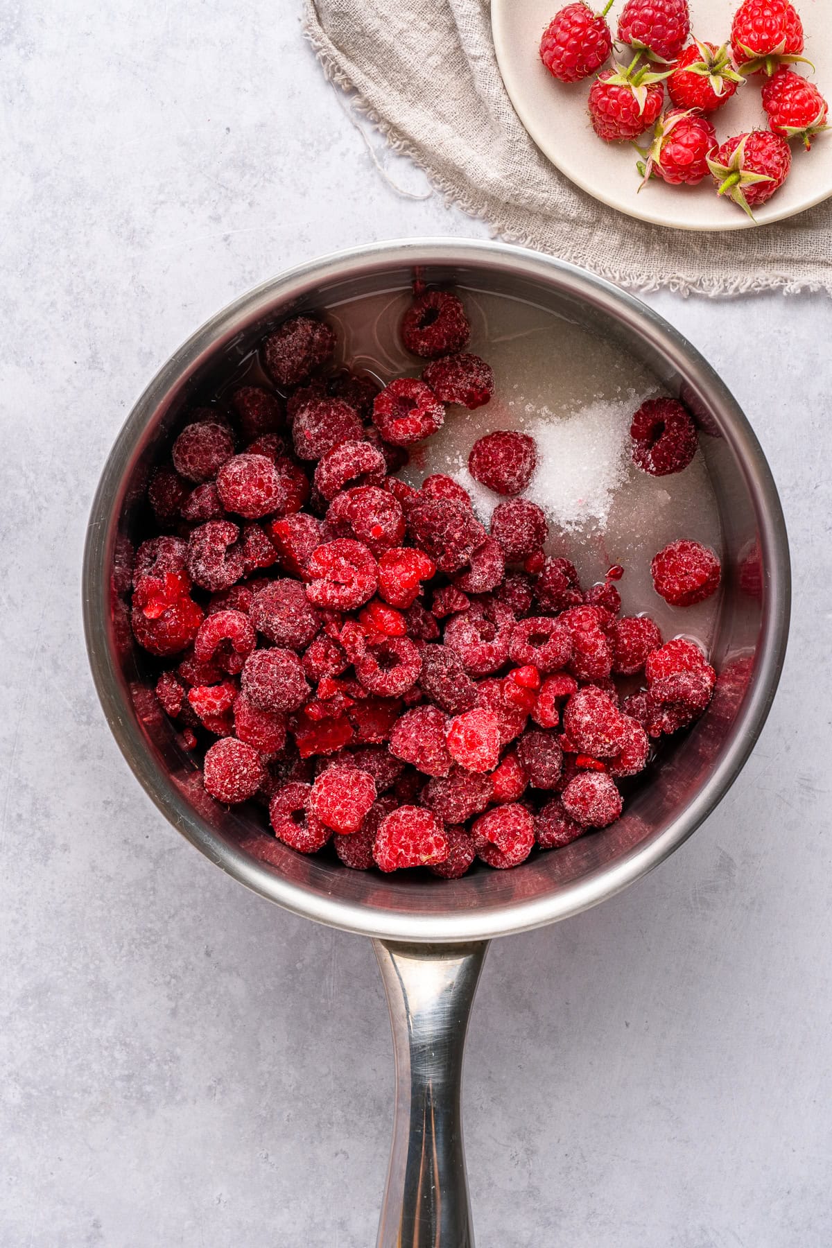 Raspberries, sugar, lemon juice and water in a pot.