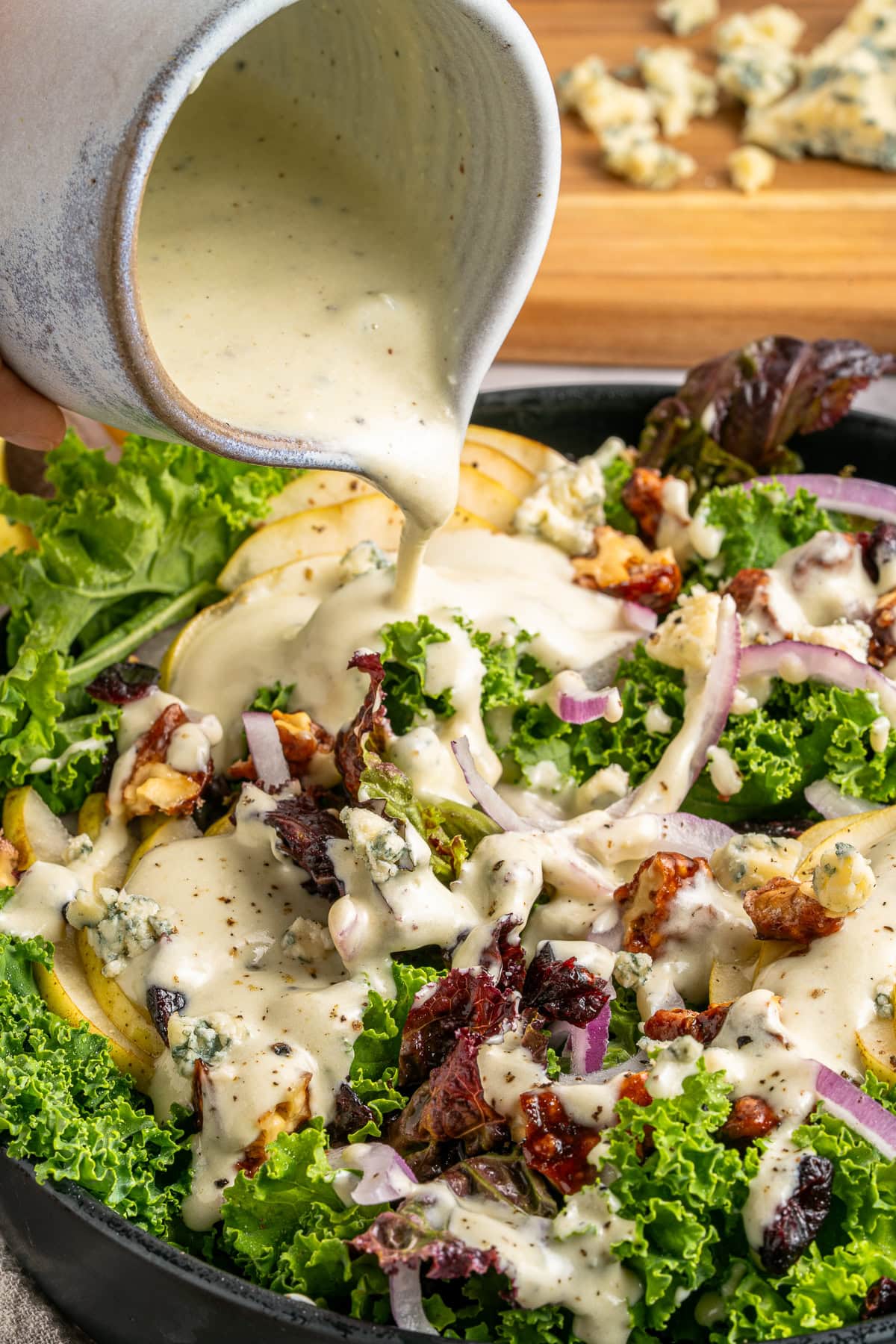 Drizzling blue cheese dressing over a salad.