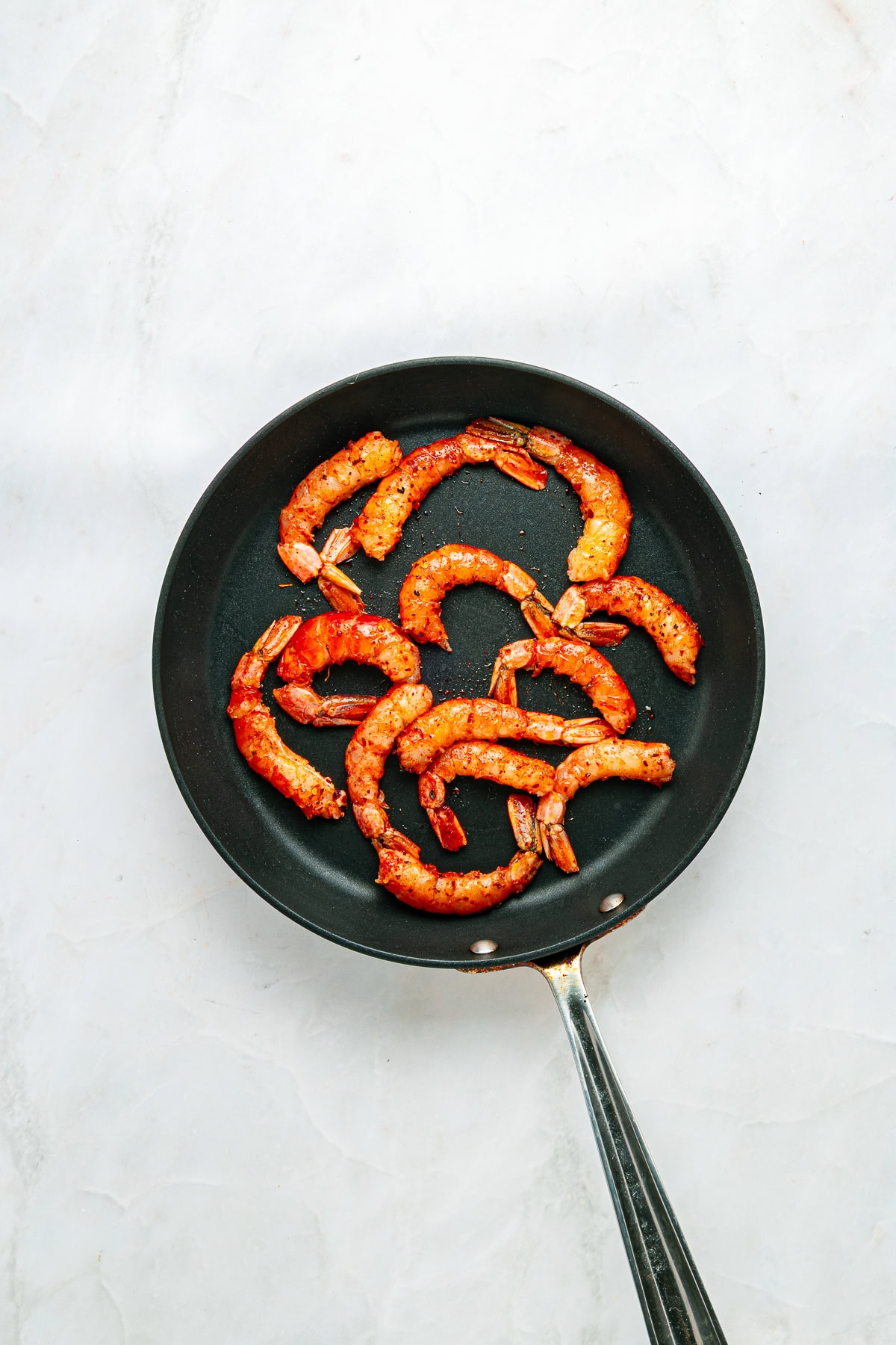 Searing seasoned shrimp.