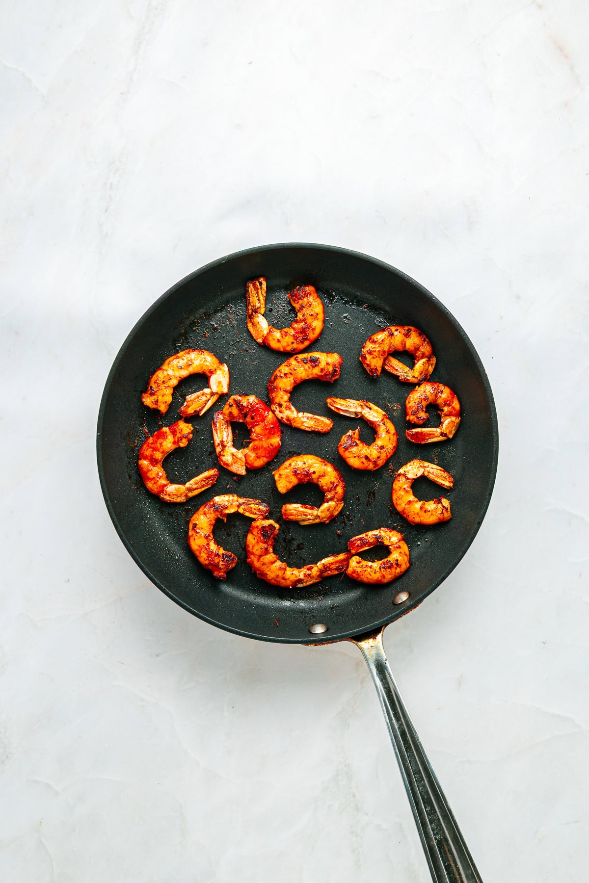 Cooked shrimp in a skillet.