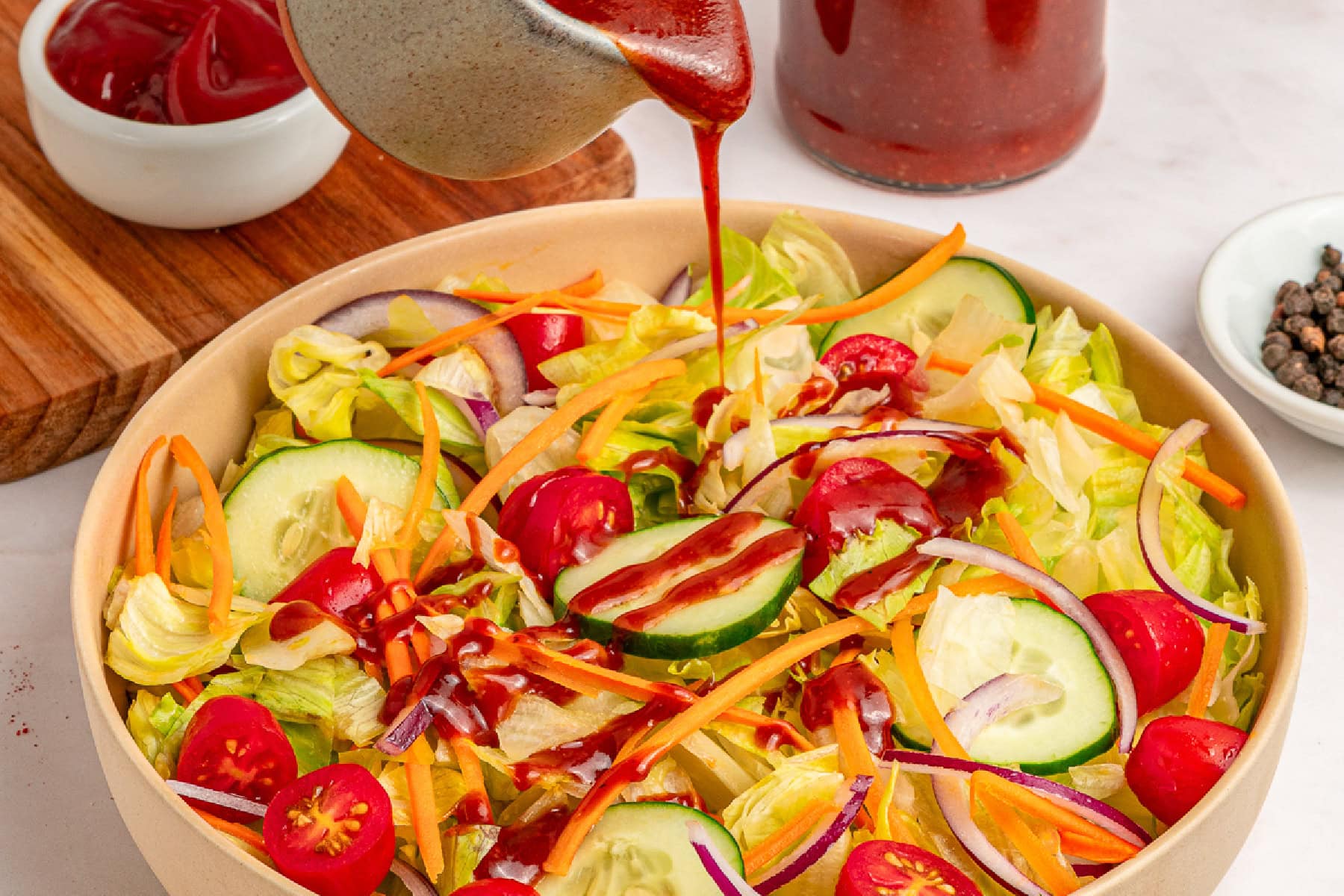 Pouring dressing over salad.