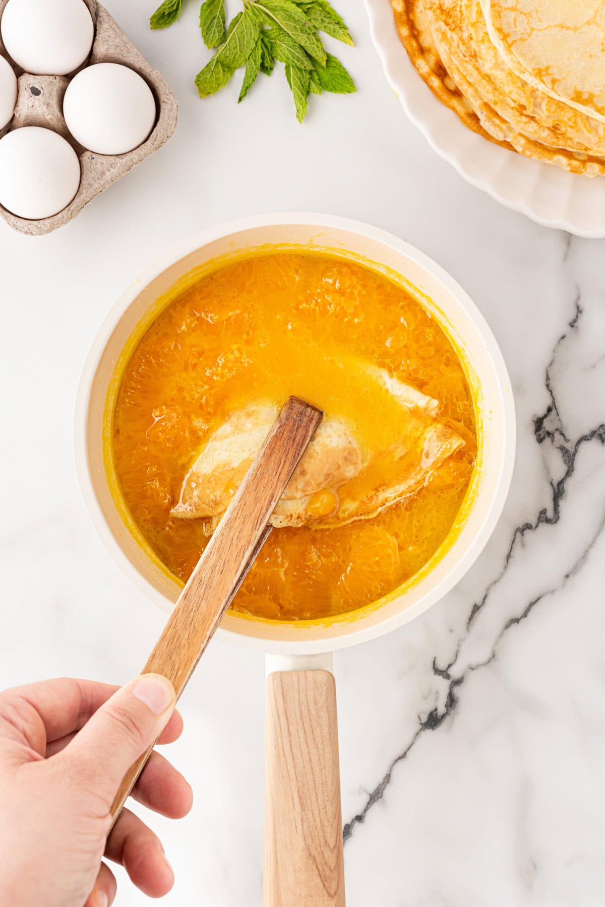 Dipping crepes in sauce.