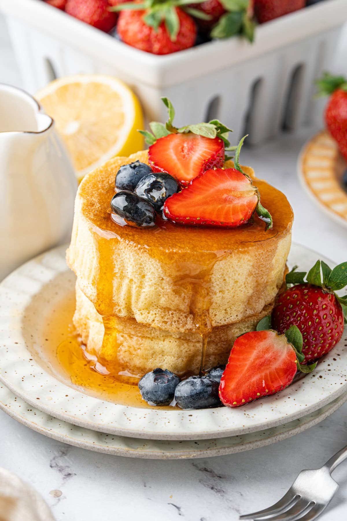 Pancakes stacked with berries and syrup.