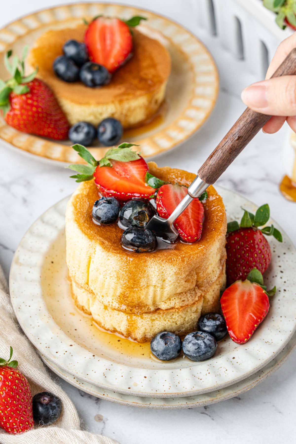 Sticking a fork into the pancakes.