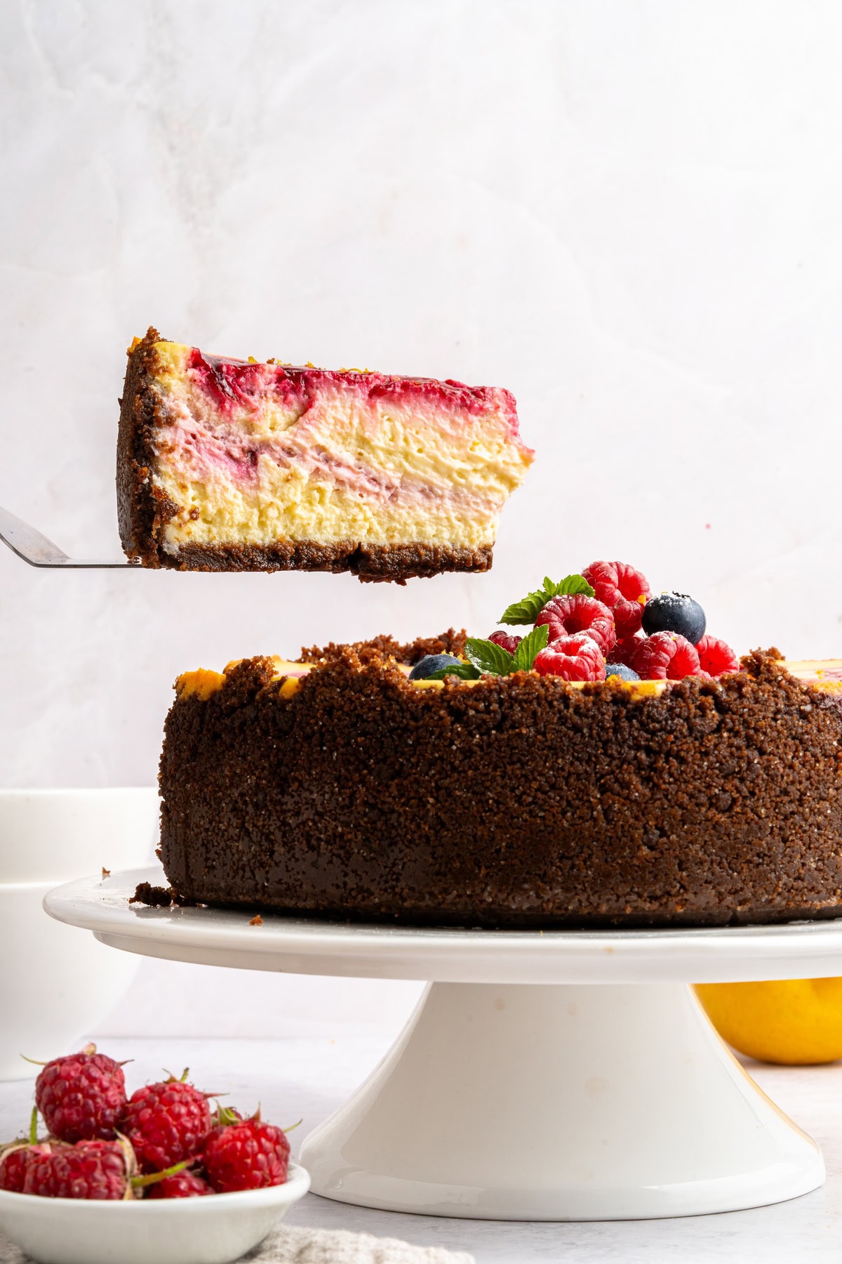 Lifting a slice of raspberry cheesecake.
