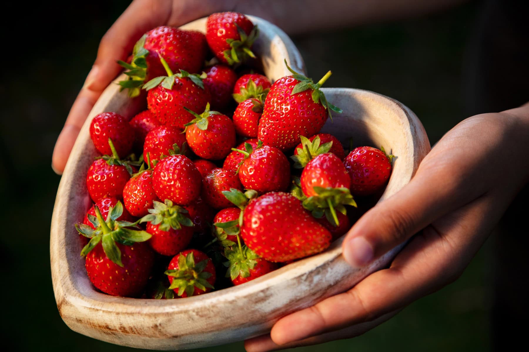 Strawberries in a heart shaped bowl.
