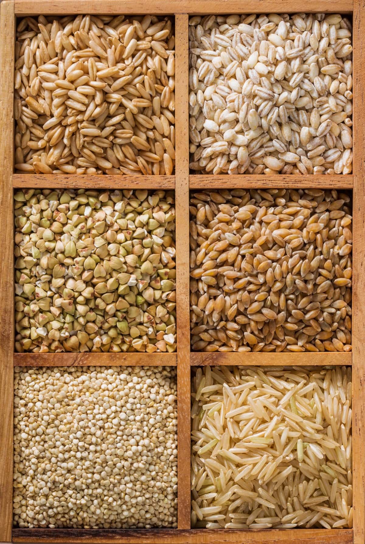 Various whole grains in wooden cubicles.