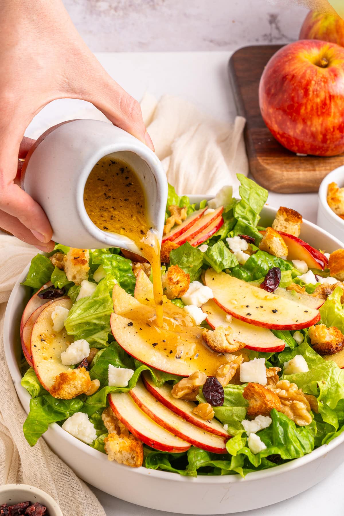 Pouring dressing on salad.