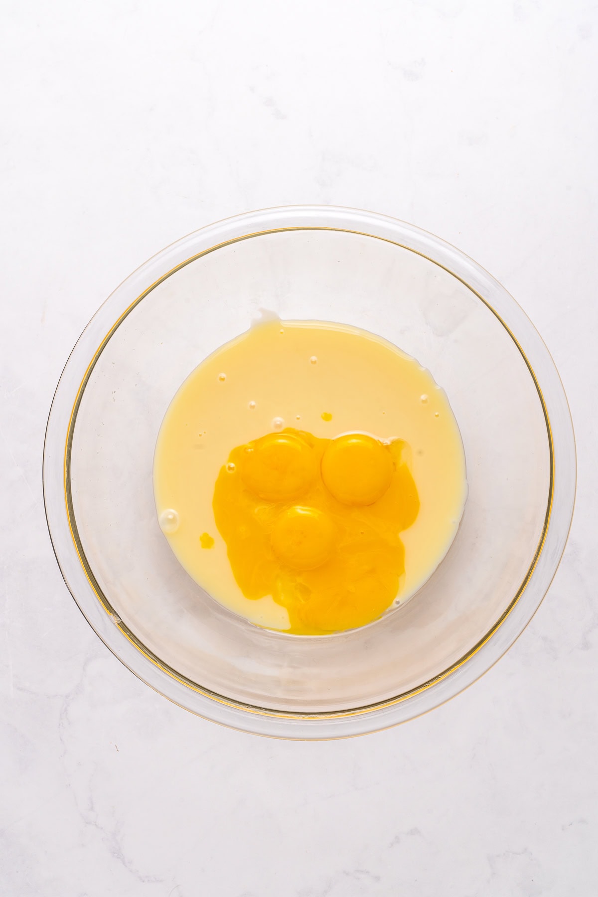 Mixing egg yolks with condensed milk.