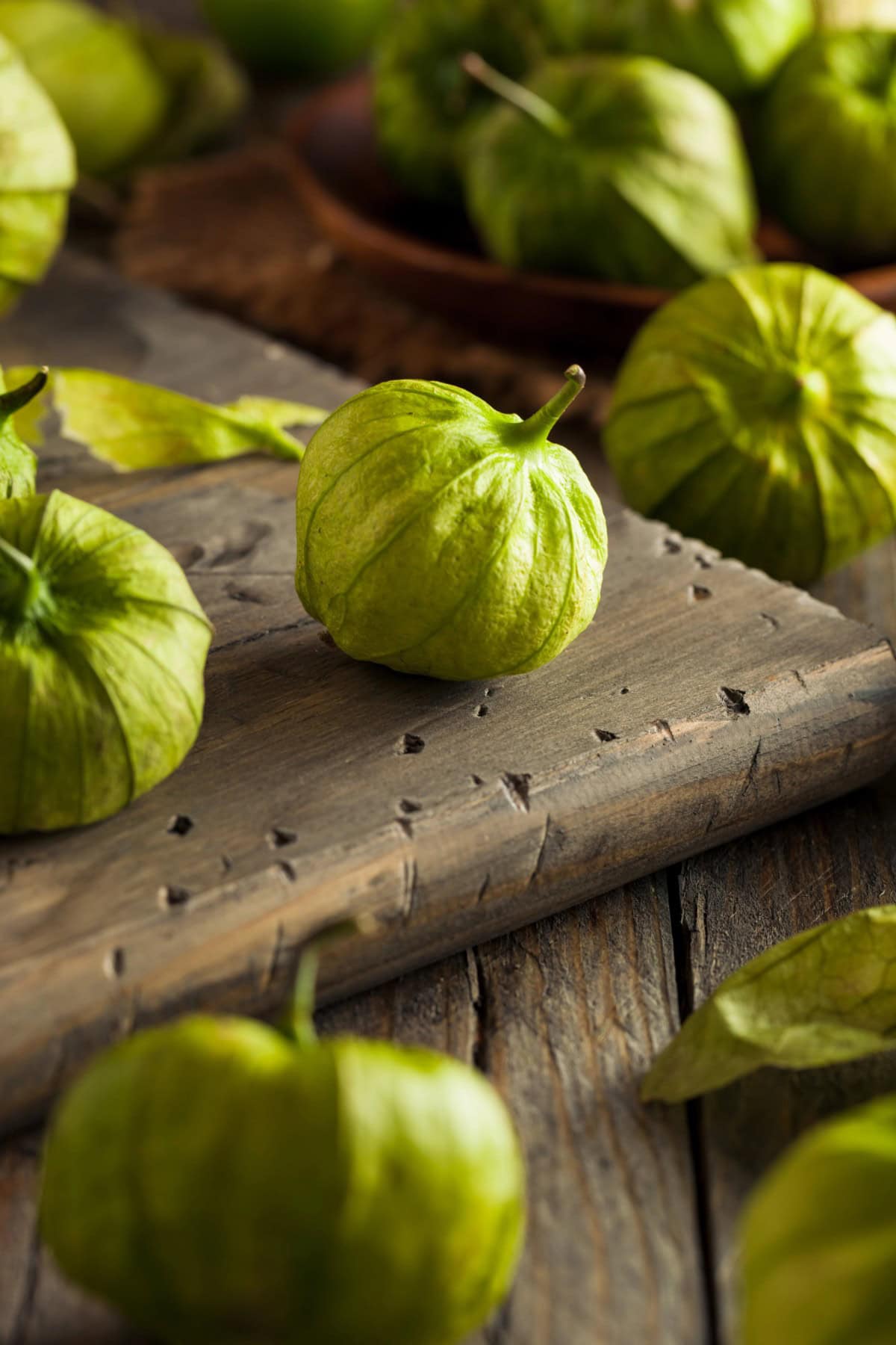 What is a Tomatillo, pictured on a wooden board.
