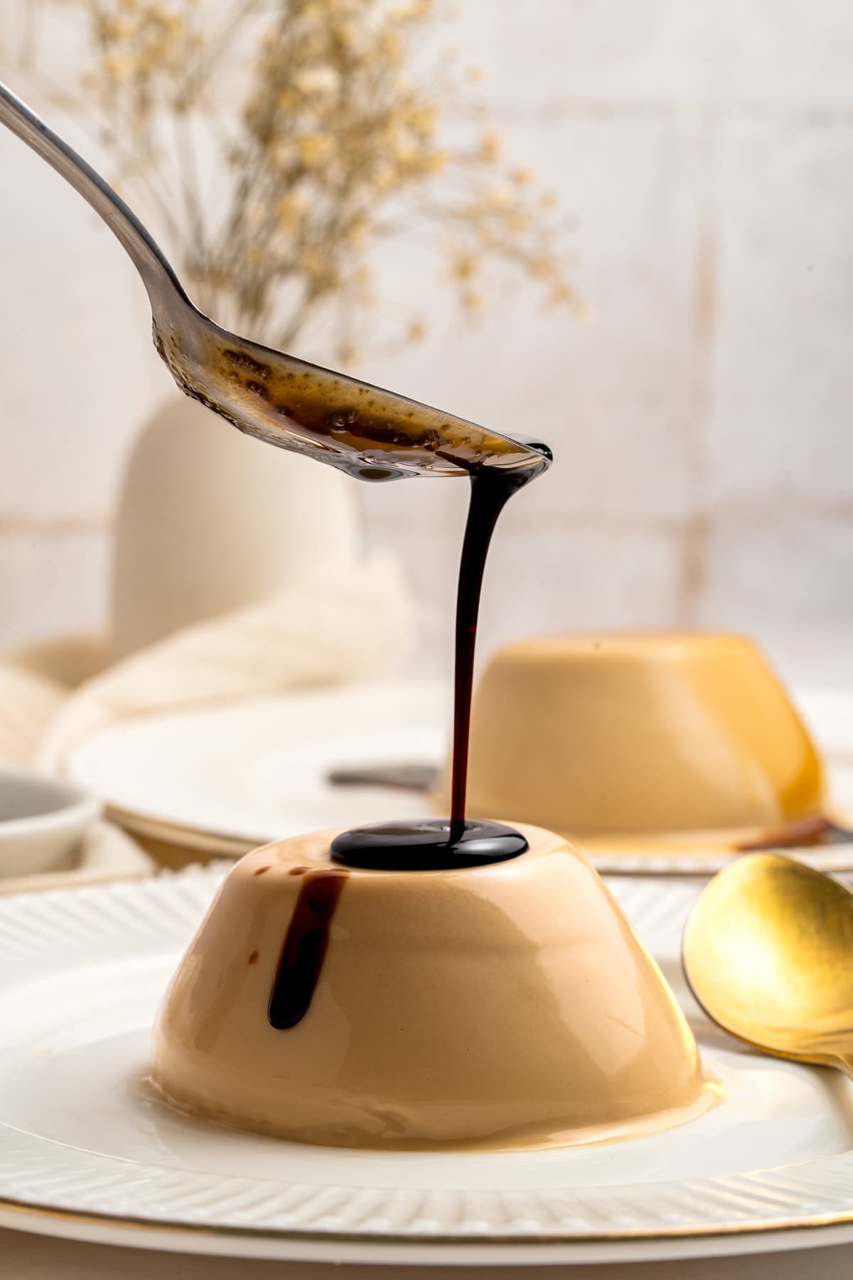 Pouring coffee syrup over panna cotta.
