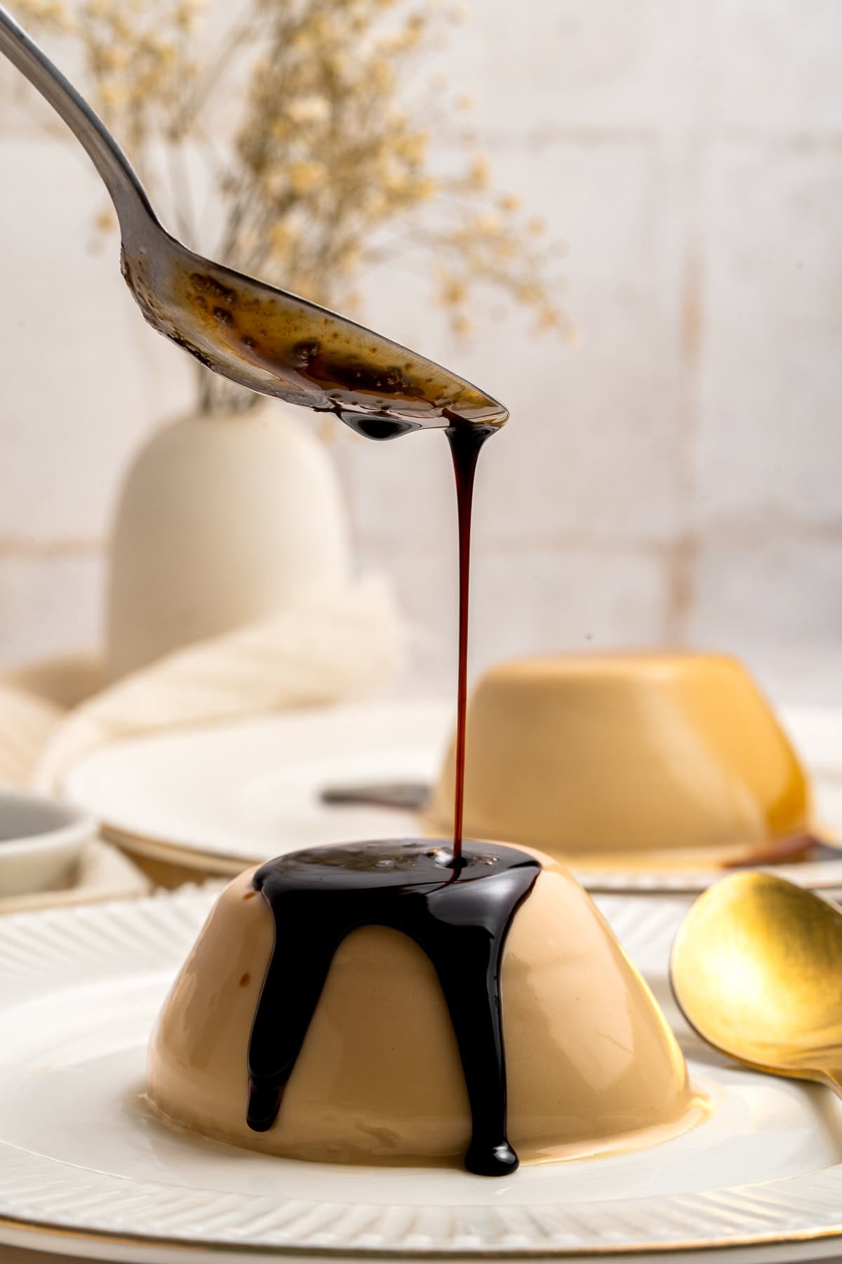 Syrup pouring over coffee panna cotta.