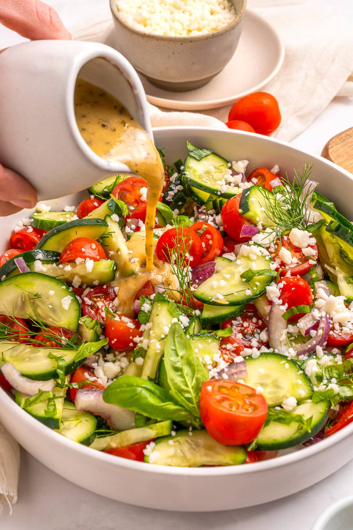 Pouring dressing over the salad.