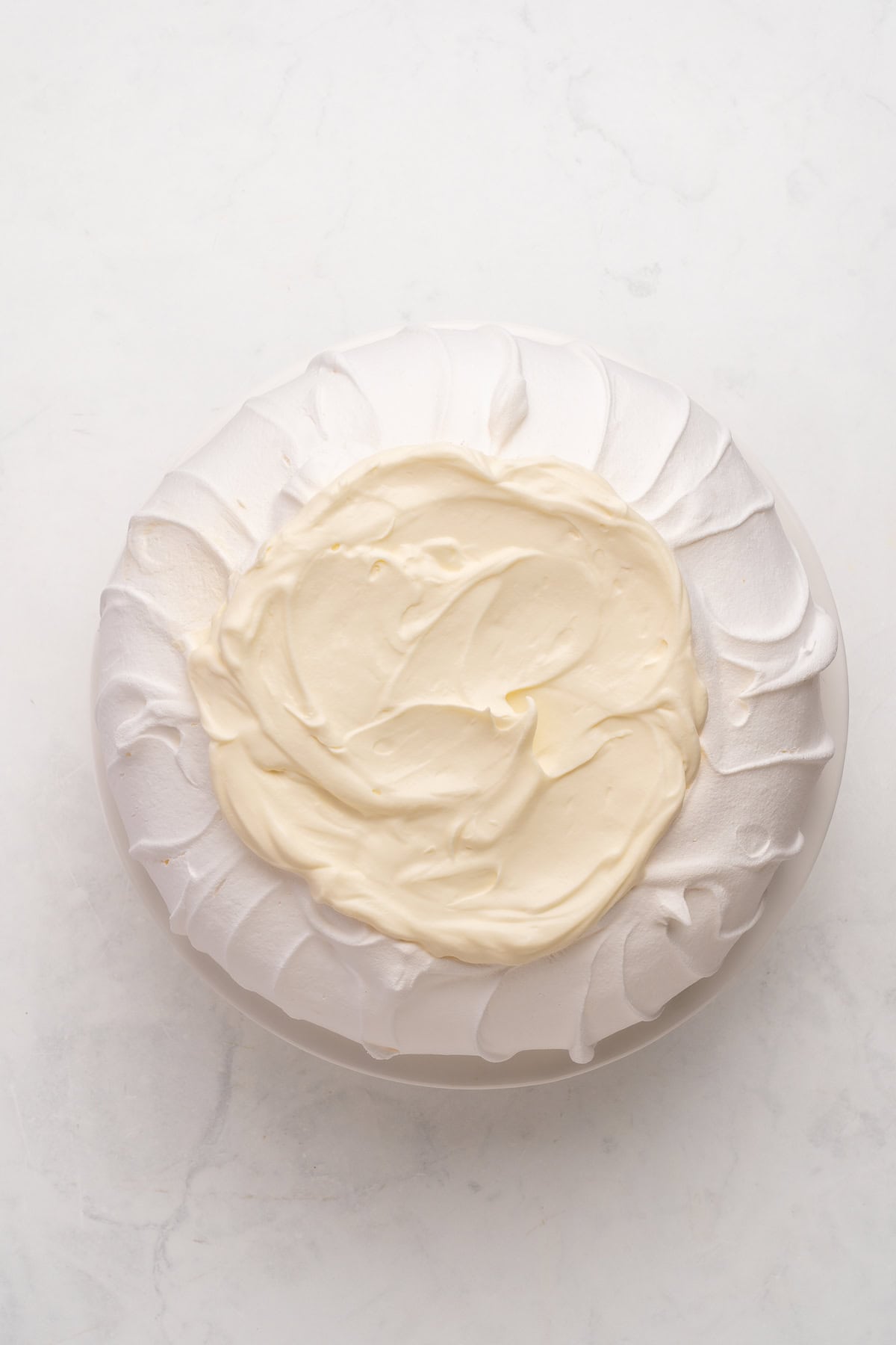 Pavlova with whipped cream topping.