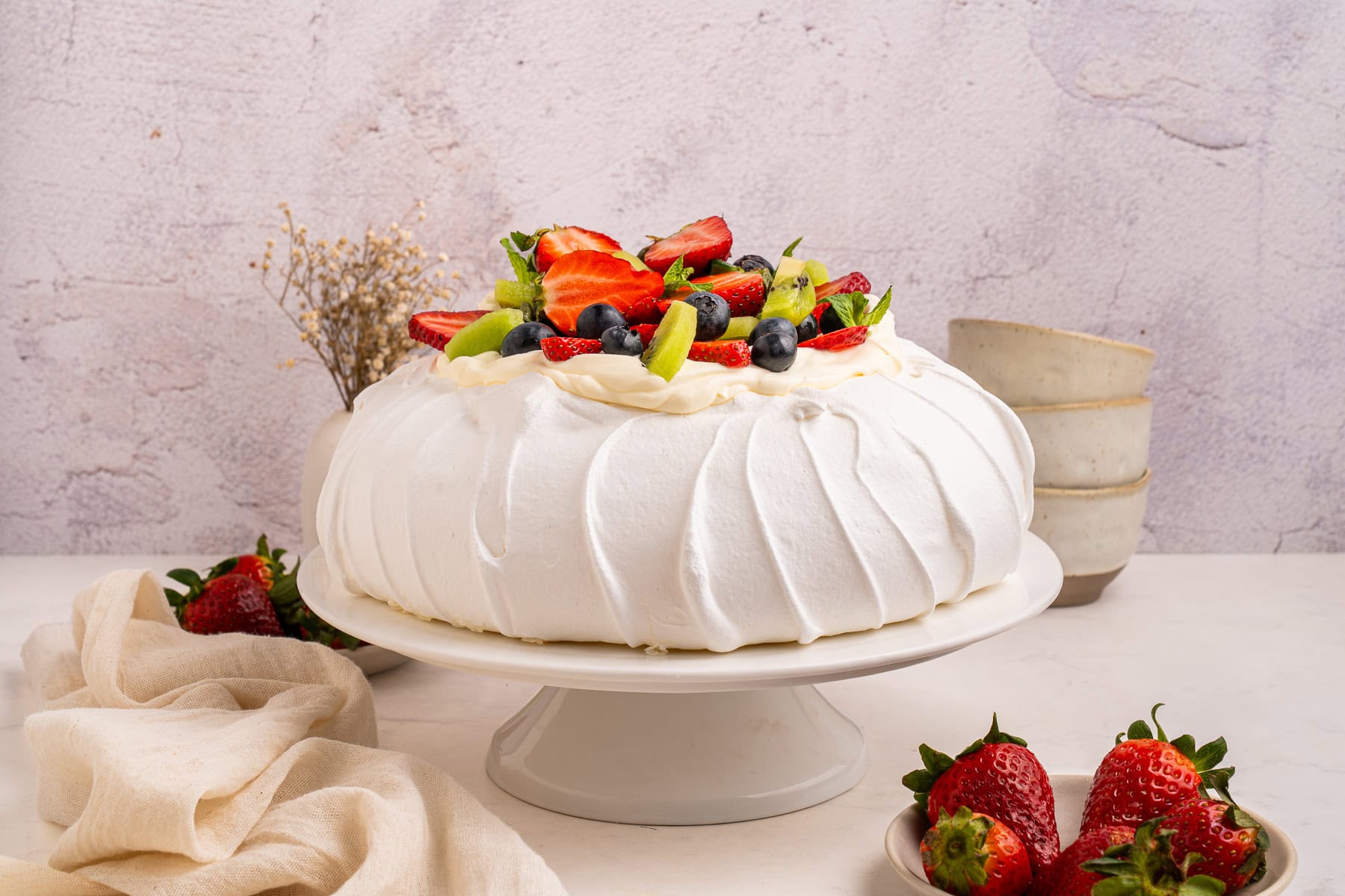 Pavlova with fruit on top, side view.