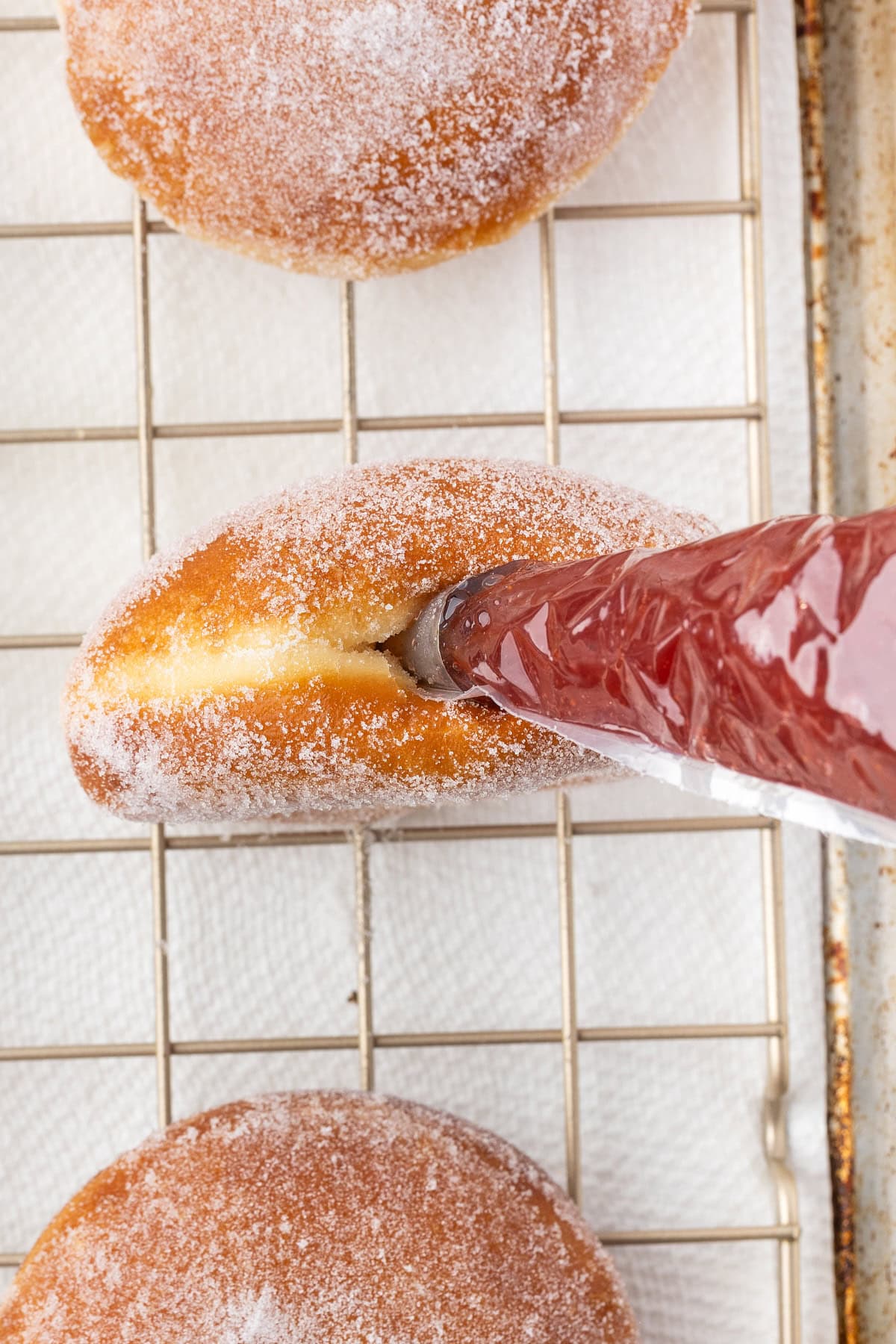 Filling the donuts with jam. 