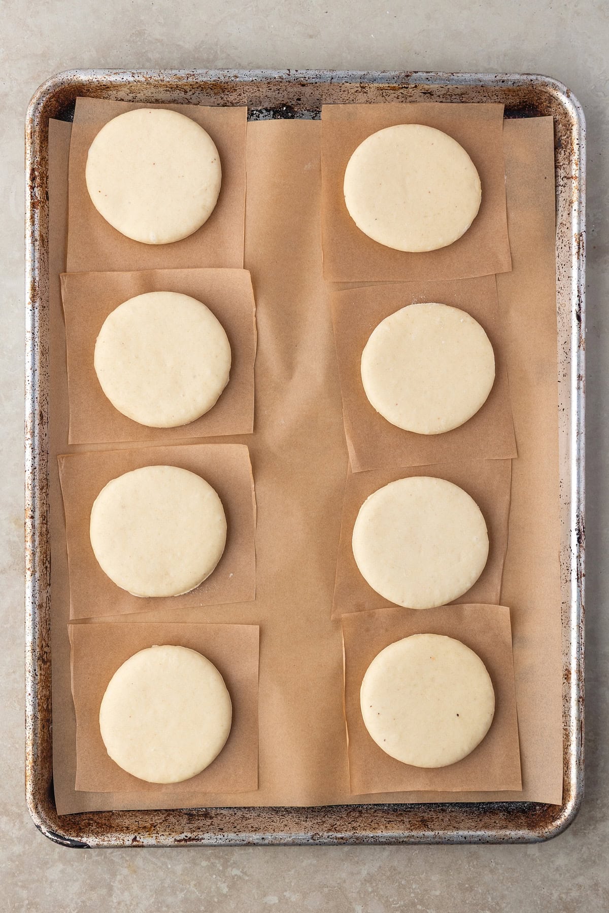 Circles on dough on parchment squares. 