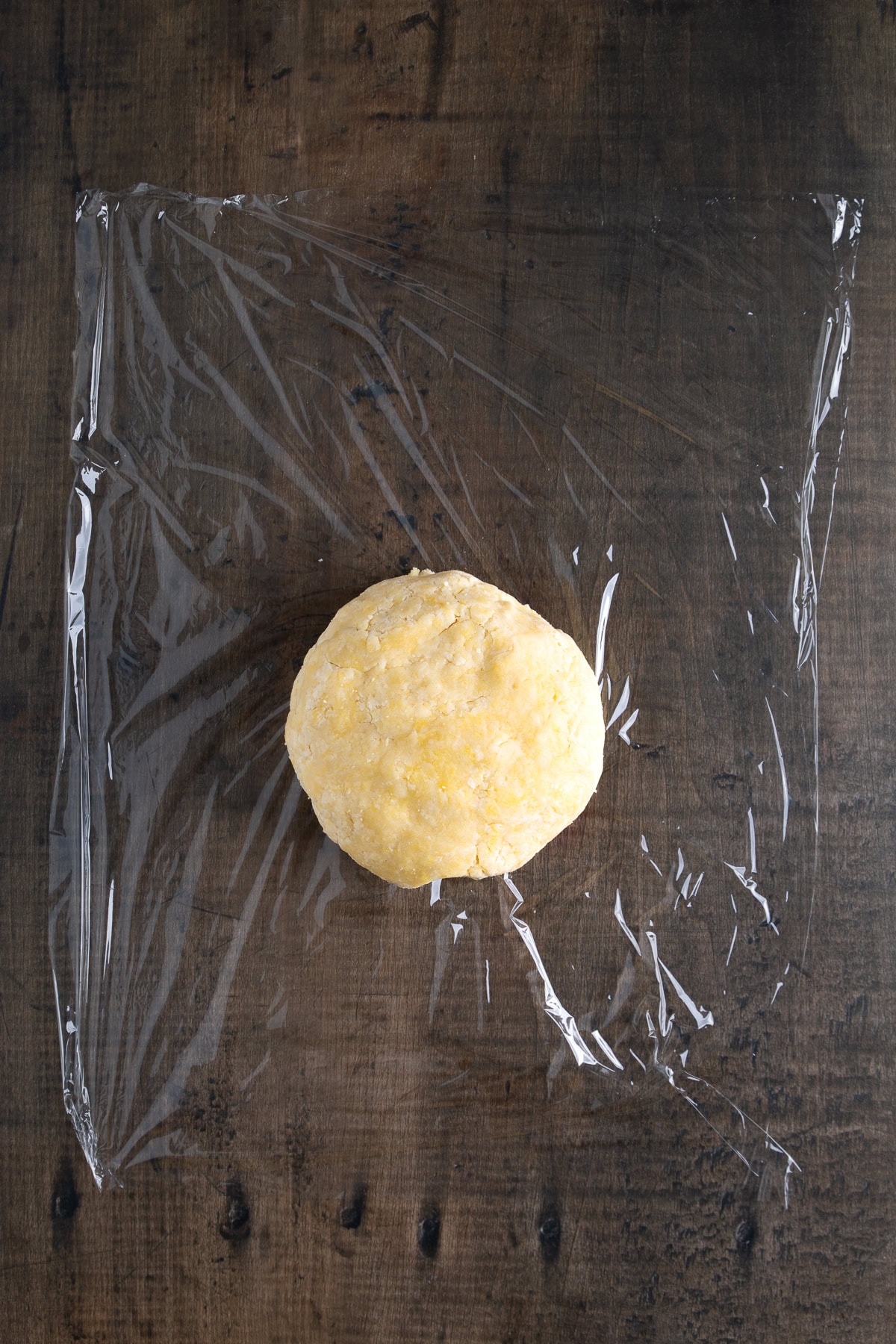 Dough ball over plastic wrap. 