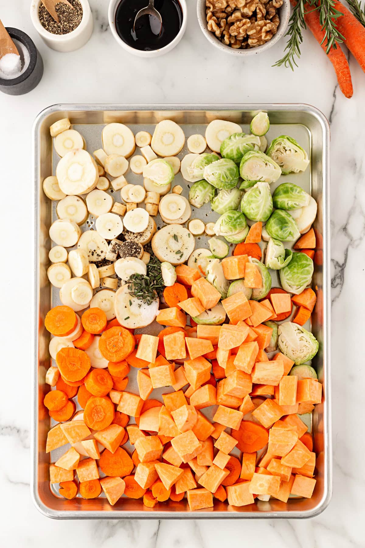 Vegetables and seasoning on a sheet pan.