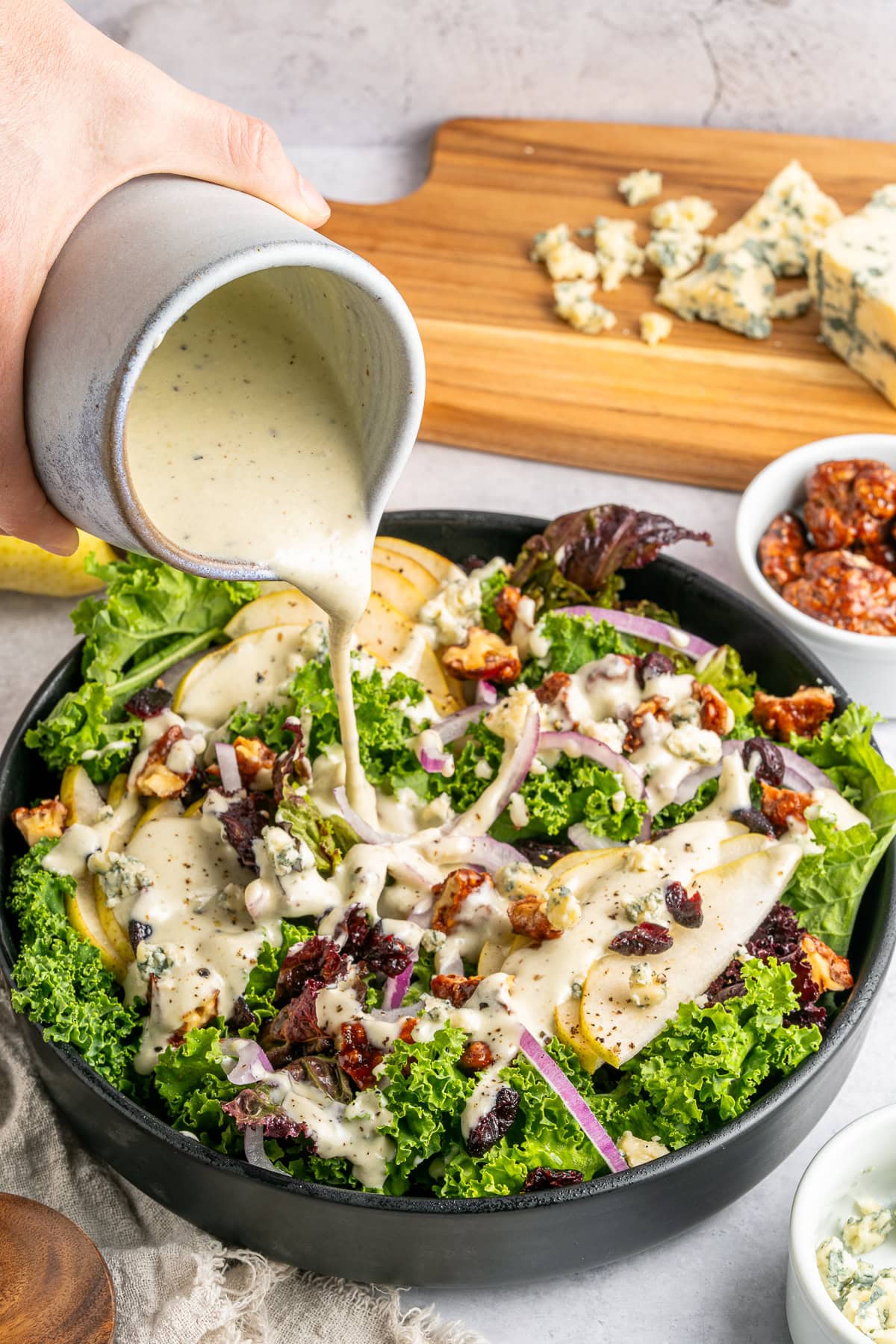 Pouring blue cheese dressing over a salad.