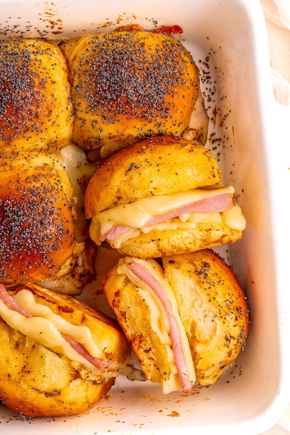 Ham and cheese sliders on a baking dish.