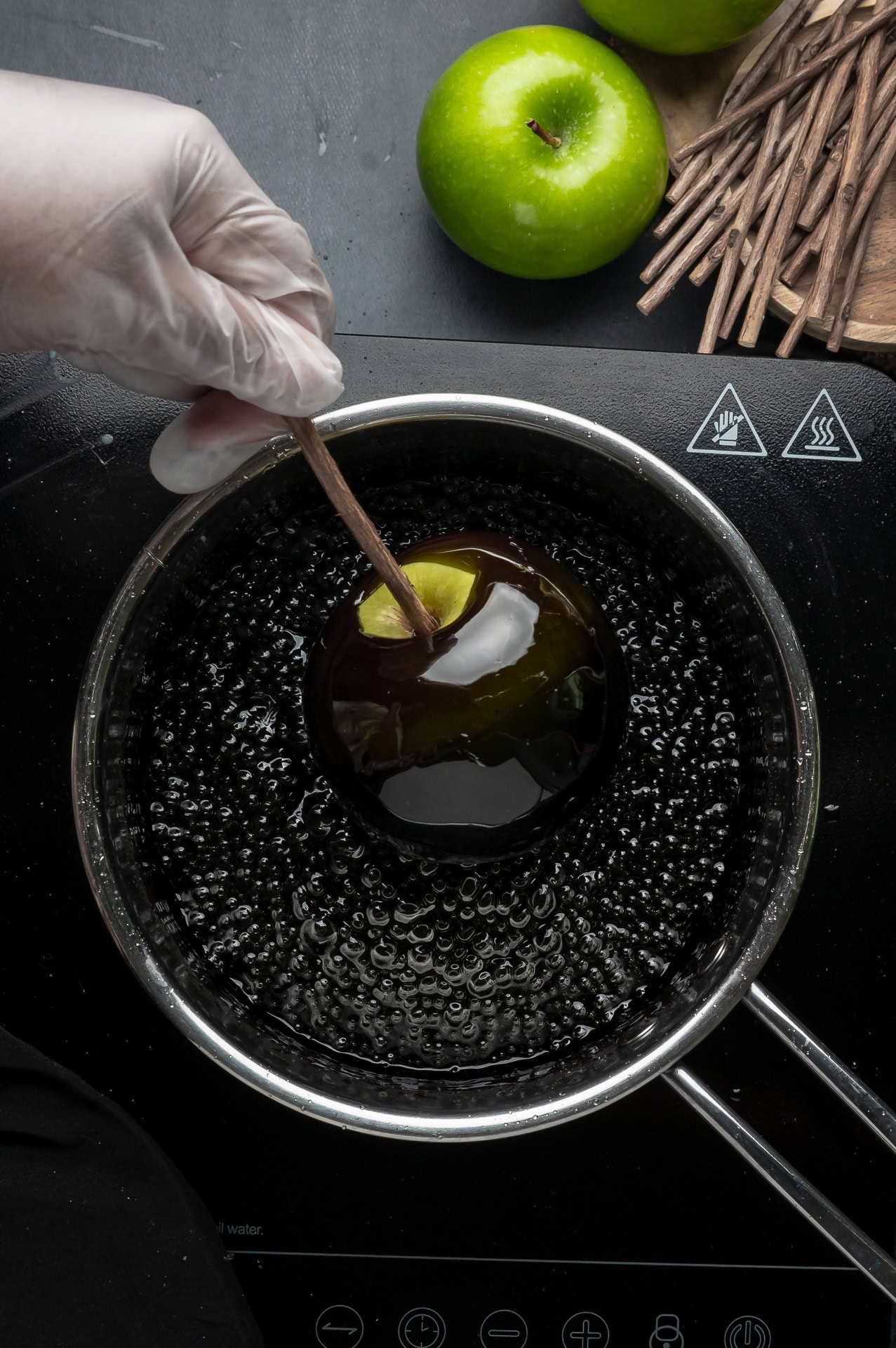 Dipping apples in to candy coating. 