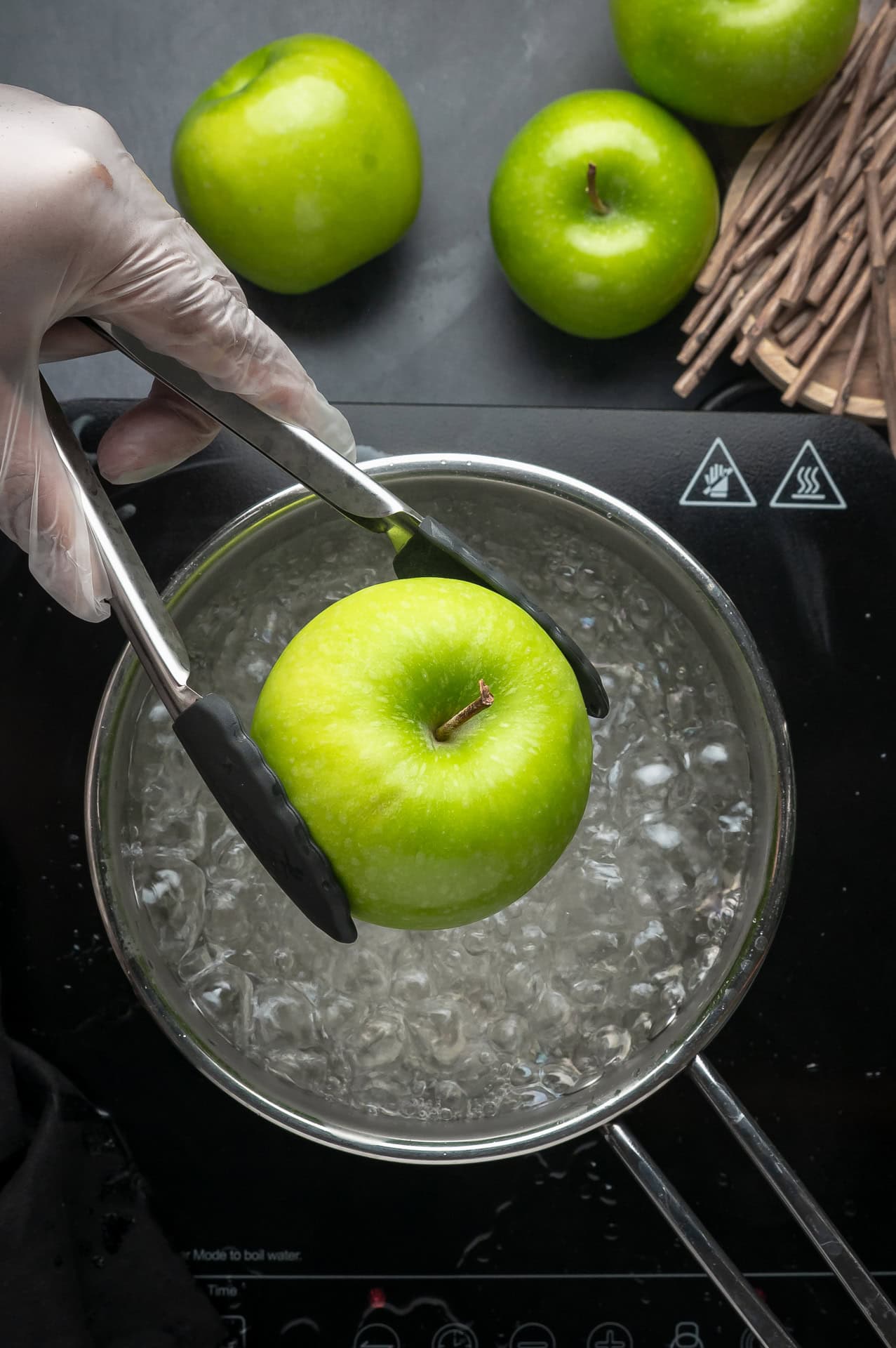 Placing apples in boiling water. 