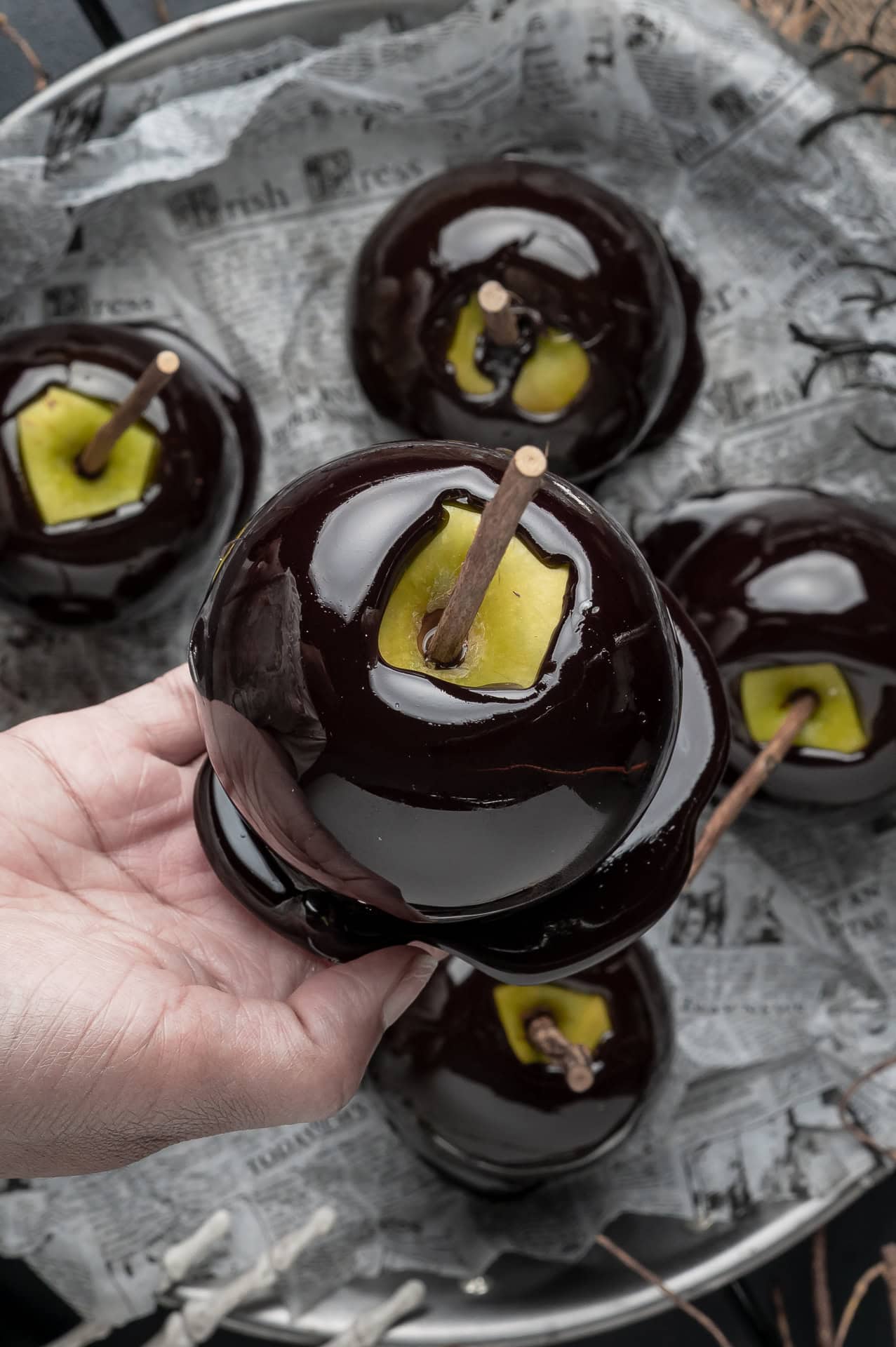 Holding a black candy apple. 