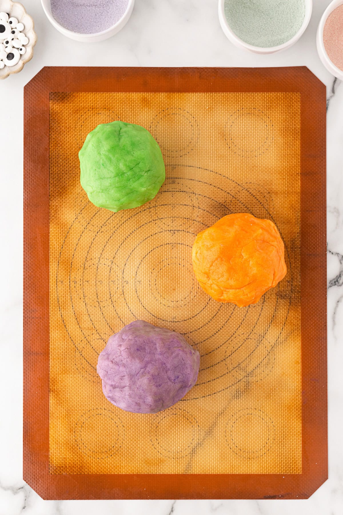 Dough in three balls colored. 