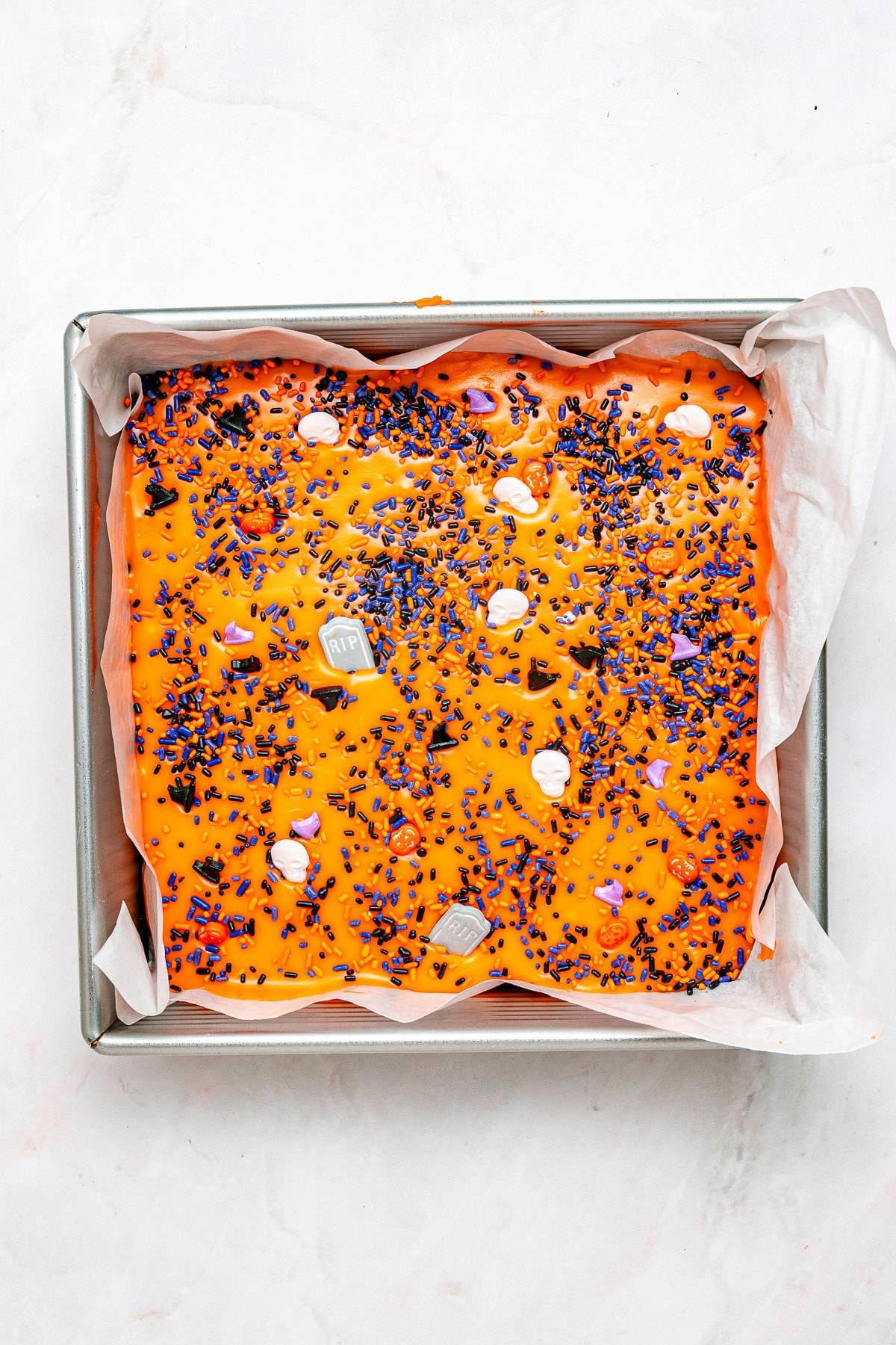 Adding halloween sprinkles to the fudge.